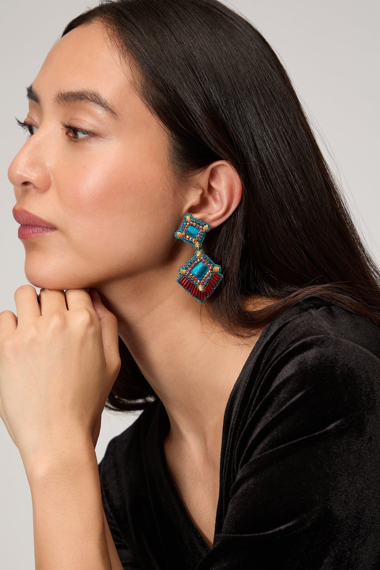 Woman in a black top poses in profile, resting her chin on her hand, wearing colorful handcrafted jewellery, including the striking Hand Embroidered Square Drop Earrings.