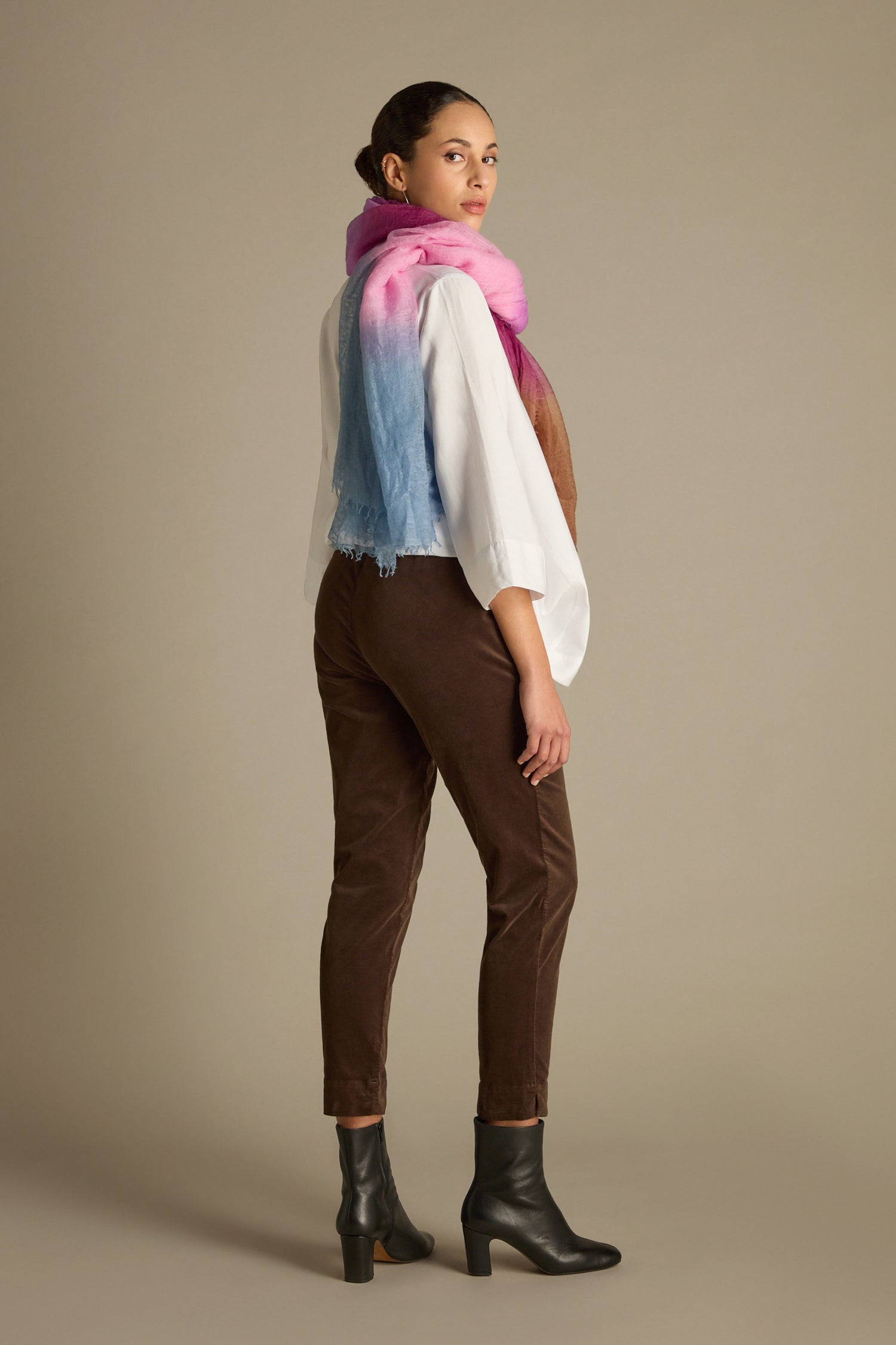 A person wearing a white shirt and the Cotton Moleskin Slim Trouser in a tailored fit, accessorized with a pink and blue scarf, is standing on a neutral background.