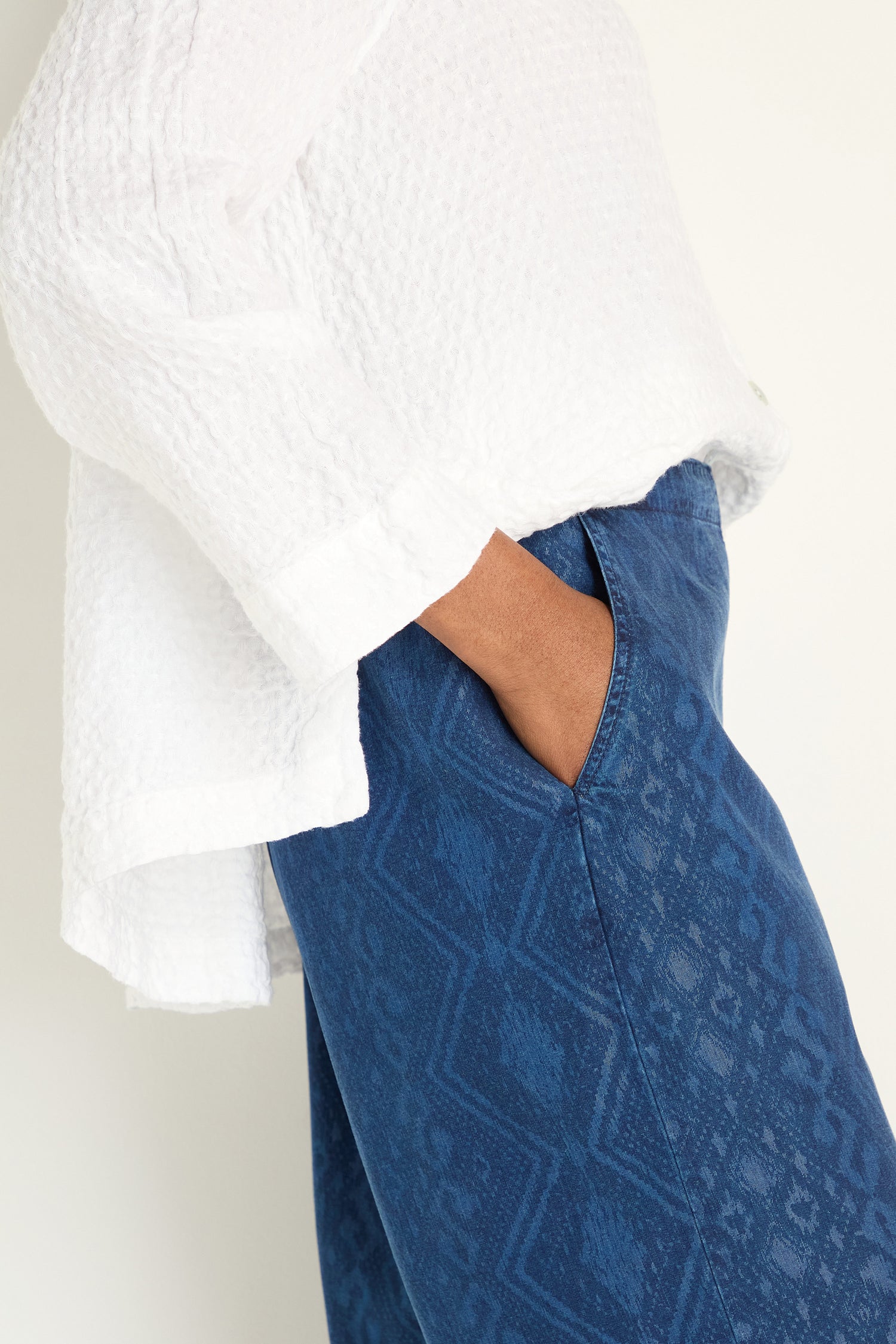 Person wearing a textured white long-sleeve shirt and Light Denim Diamond Patchwork Print Bubble Trousers with an elasticated waistband, one hand in pocket, standing against a plain background.