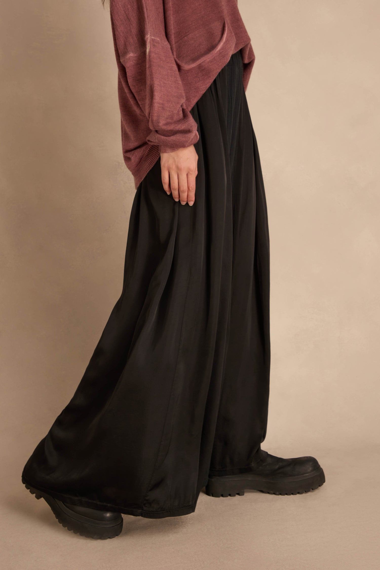 A person wearing a plum-colored sweater, Black Wide Leg Panel Trousers, and chunky black boots.