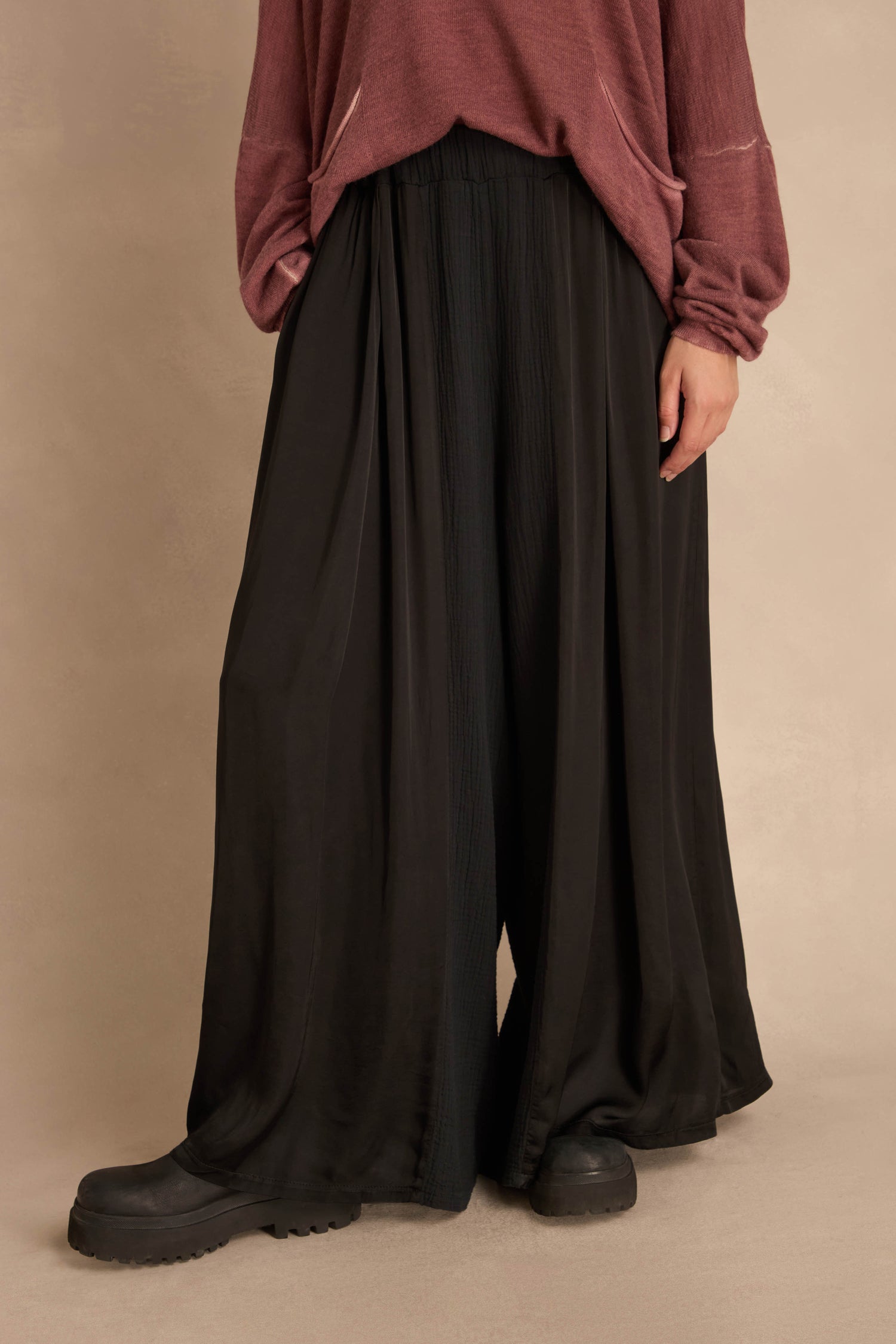 Black Wide Leg Panel Trousers worn with a mauve long-sleeved top and black platform shoes.