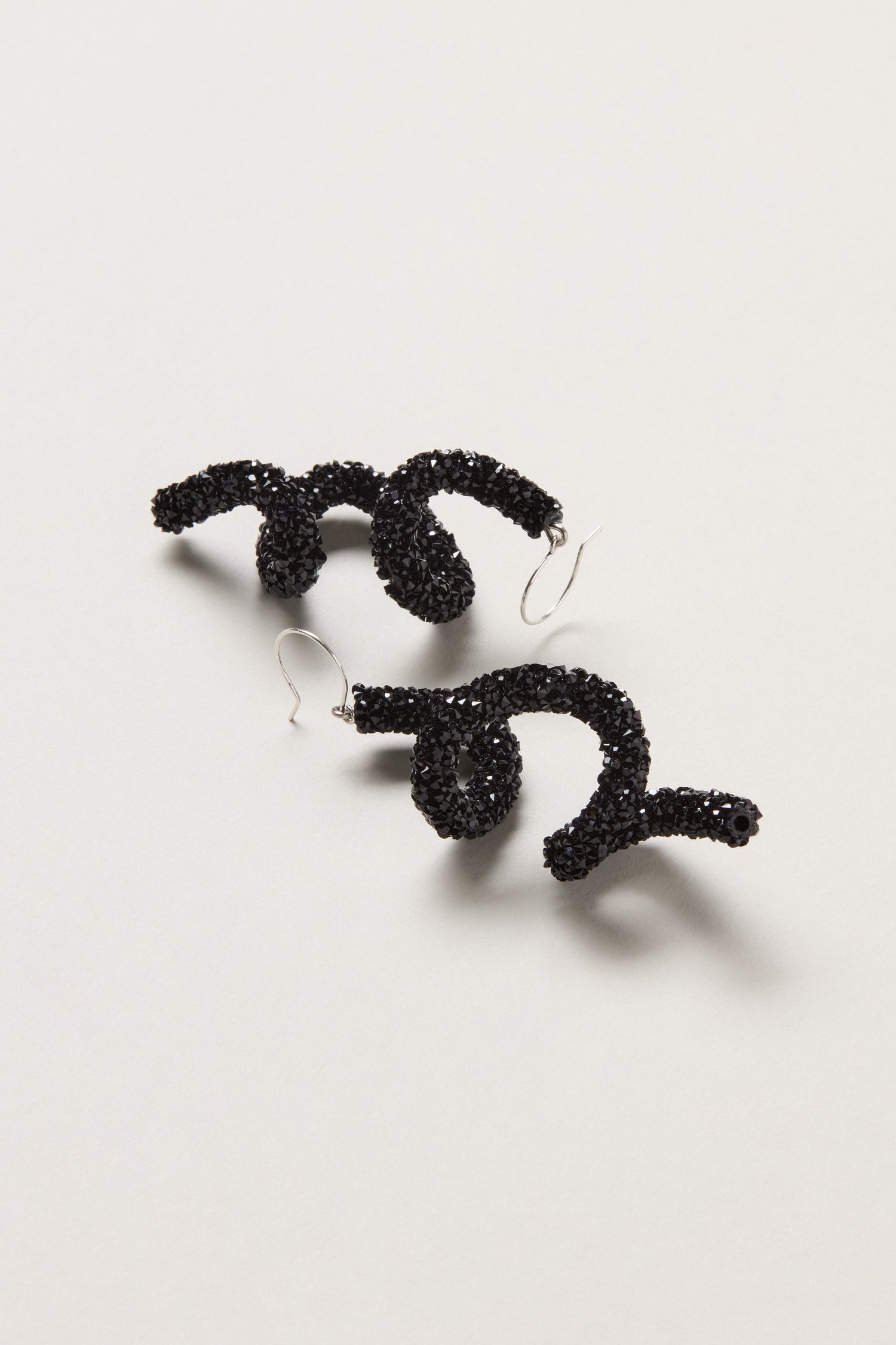 Disco Sketch Black Earrings by Samuel Coraux feature an abstract, twisted design with black beads—statement jewellery for any occasion, shown on a light background.