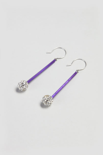 The Disco Ball Earrings feature purple bars and round, faceted clear crystals on silver hooks, offering a stylish contemporary touch. Elegantly displayed on a light background, these earrings enhance any modern jewellery collection.