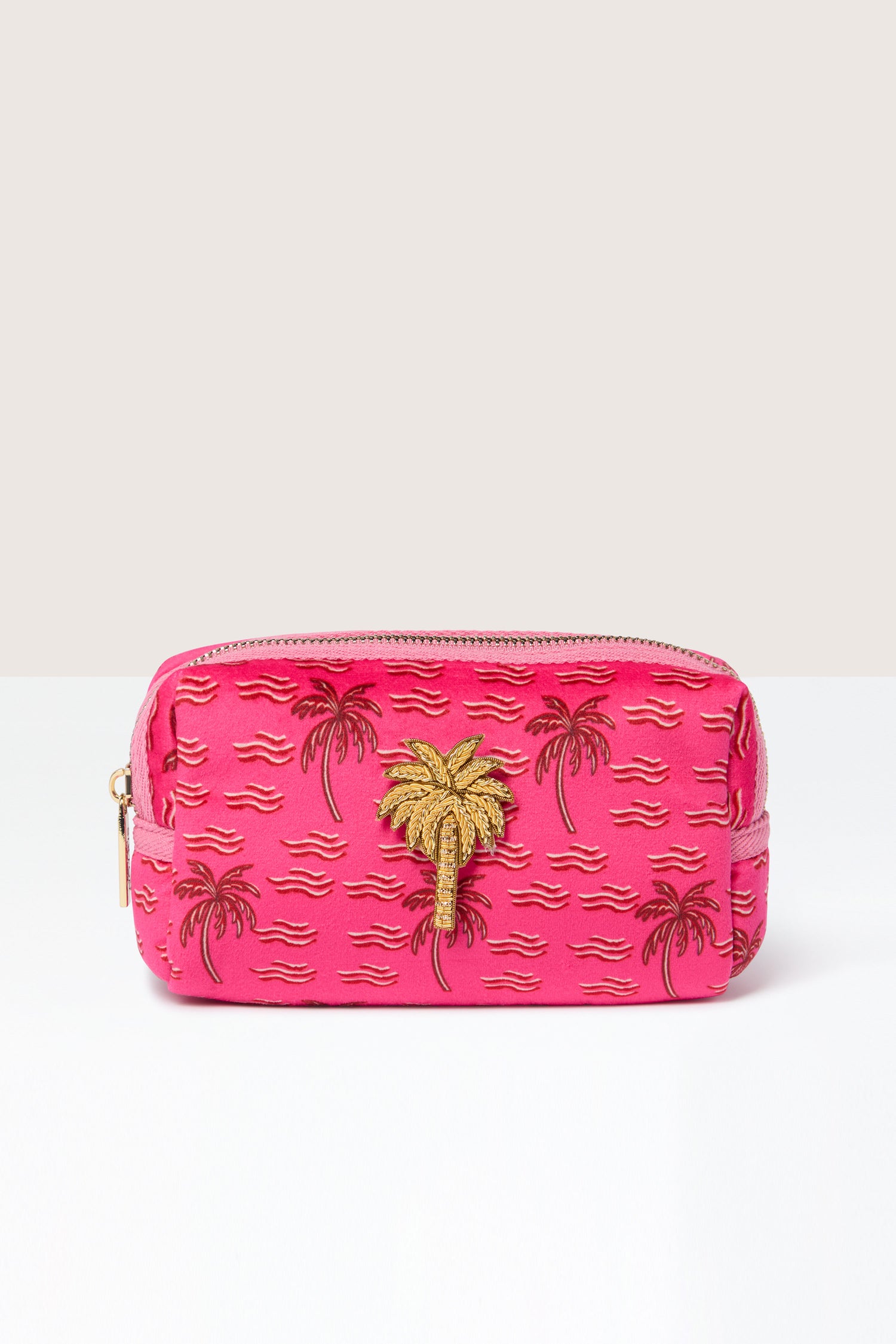 Introducing the Small Palm Make-Up Bag: a pink fabric pouch adorned with embroidered palm trees and wave patterns, highlighted by a gold zipper. Perfect for your beauty essentials, this bag captures tropical vibes in every stitch.