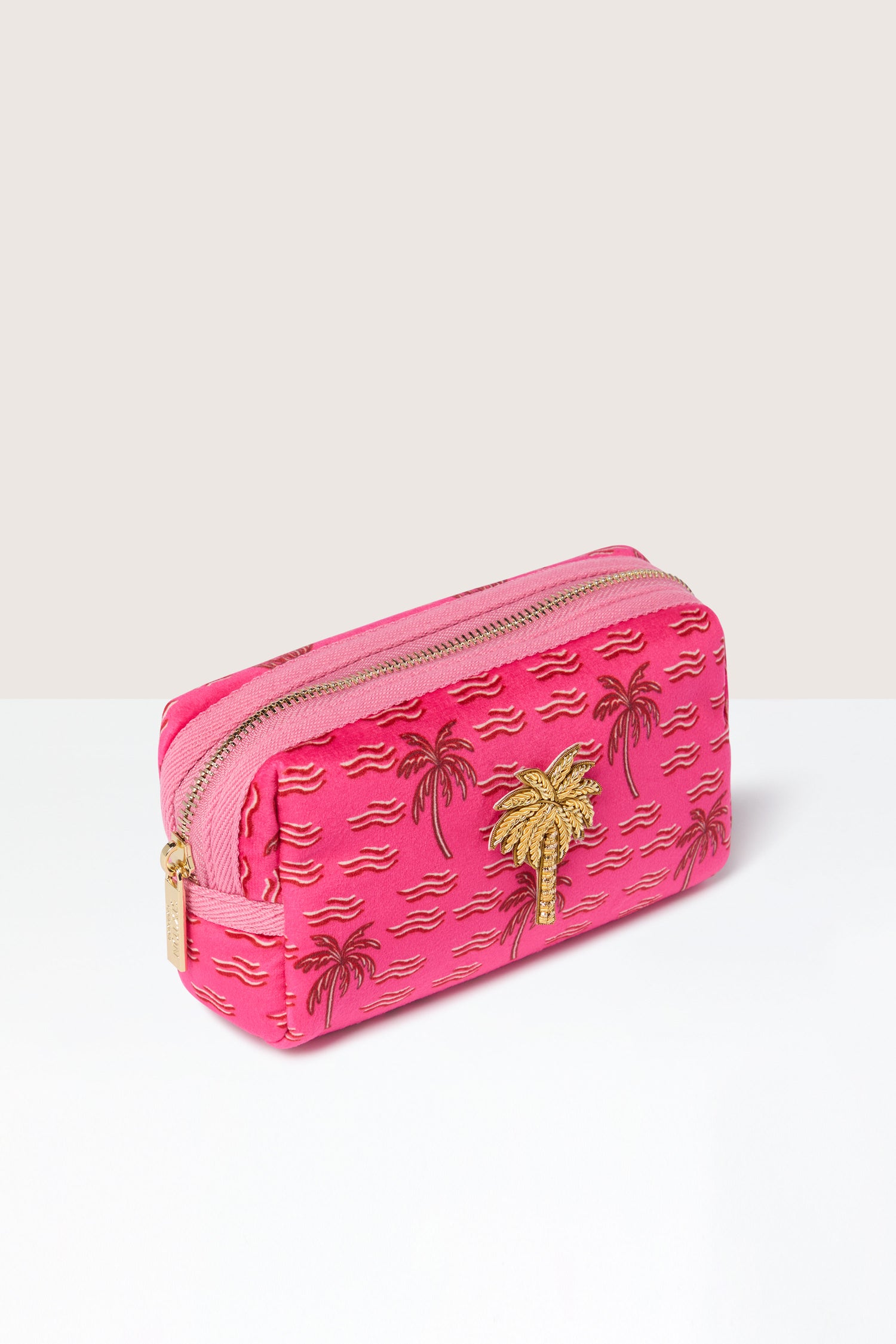 Small Palm Make-up Bag: This pink zippered pouch, featuring embroidered gold palm trees and wave patterns against a white and beige background, exudes tropical vibes. It's the perfect companion for your beauty essentials.