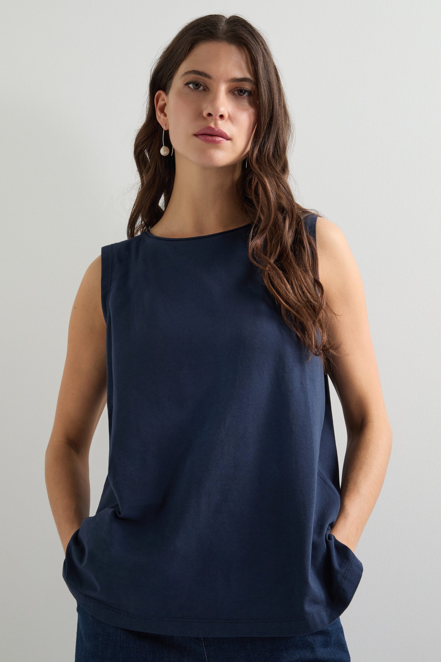 A woman with long hair wears a Cotton Jersey Boxy Vest in navy, standing against a plain white background.