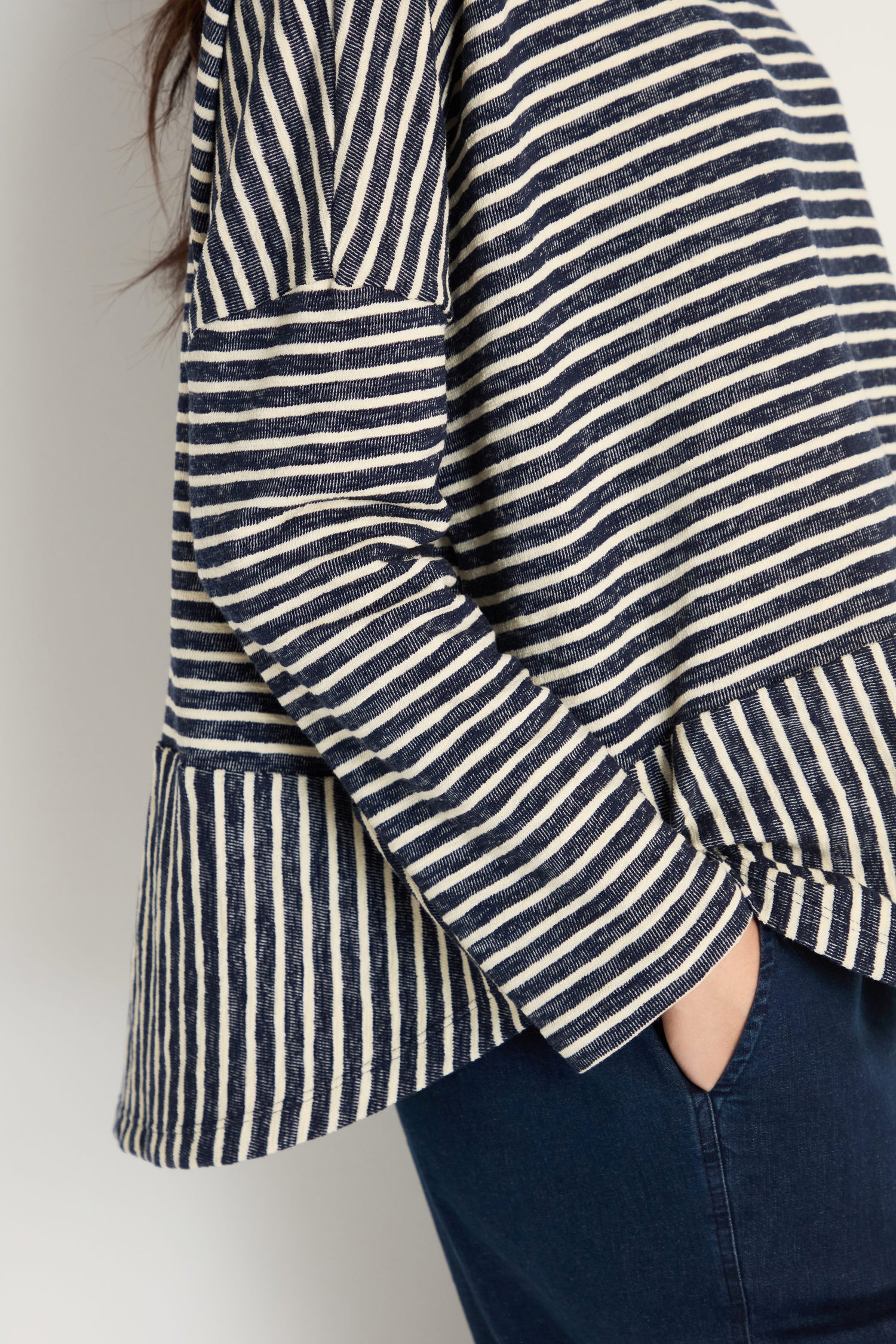 A person wearing the Textured Stripe Jersey Boxy Top in navy and white with dark blue pants, one hand in their pocket.