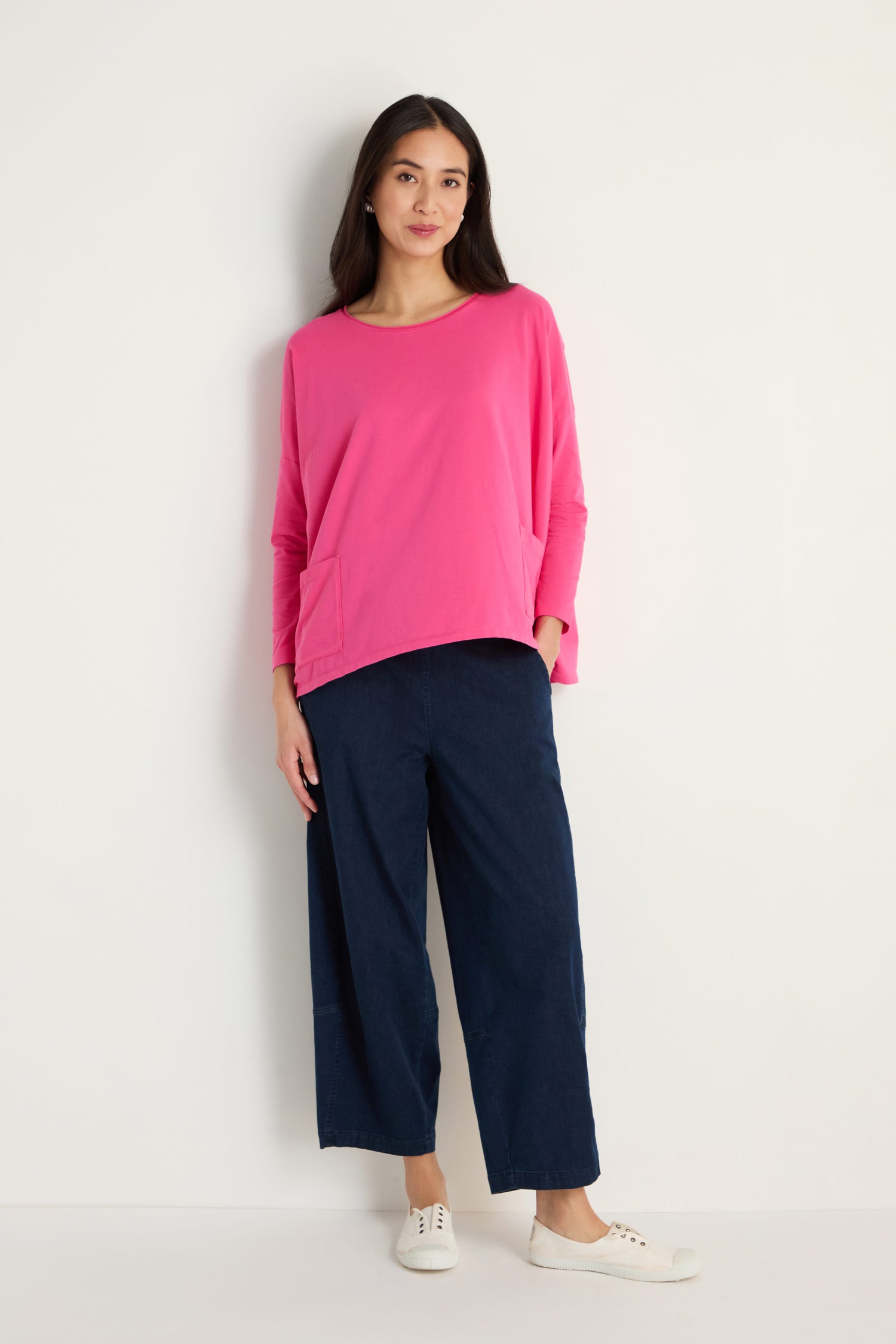 A woman wears a Cotton Jersey Boxy Pocket Top in pink and blue pants.