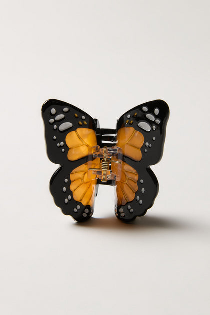 A Hand-Painted Mini Monarch Butterfly Hair Clip, showcasing intricate black, orange, and white monarch wing details, is displayed upright against a plain light background.