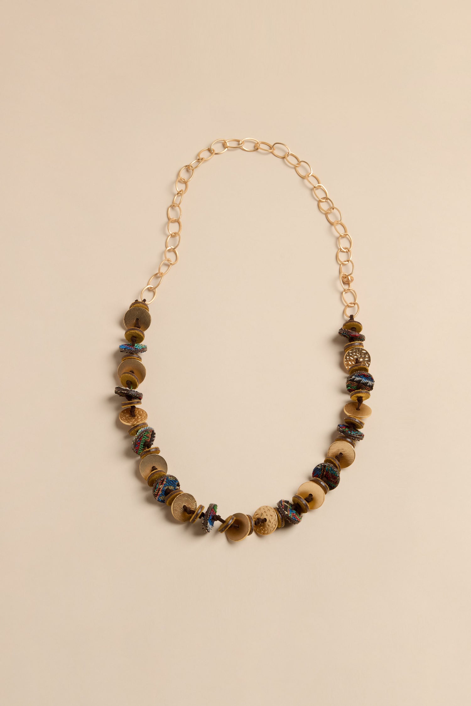 Textured Disc Necklace featuring a gold chain with a series of textured disc charms in brown, tan, and multi-colored tones.