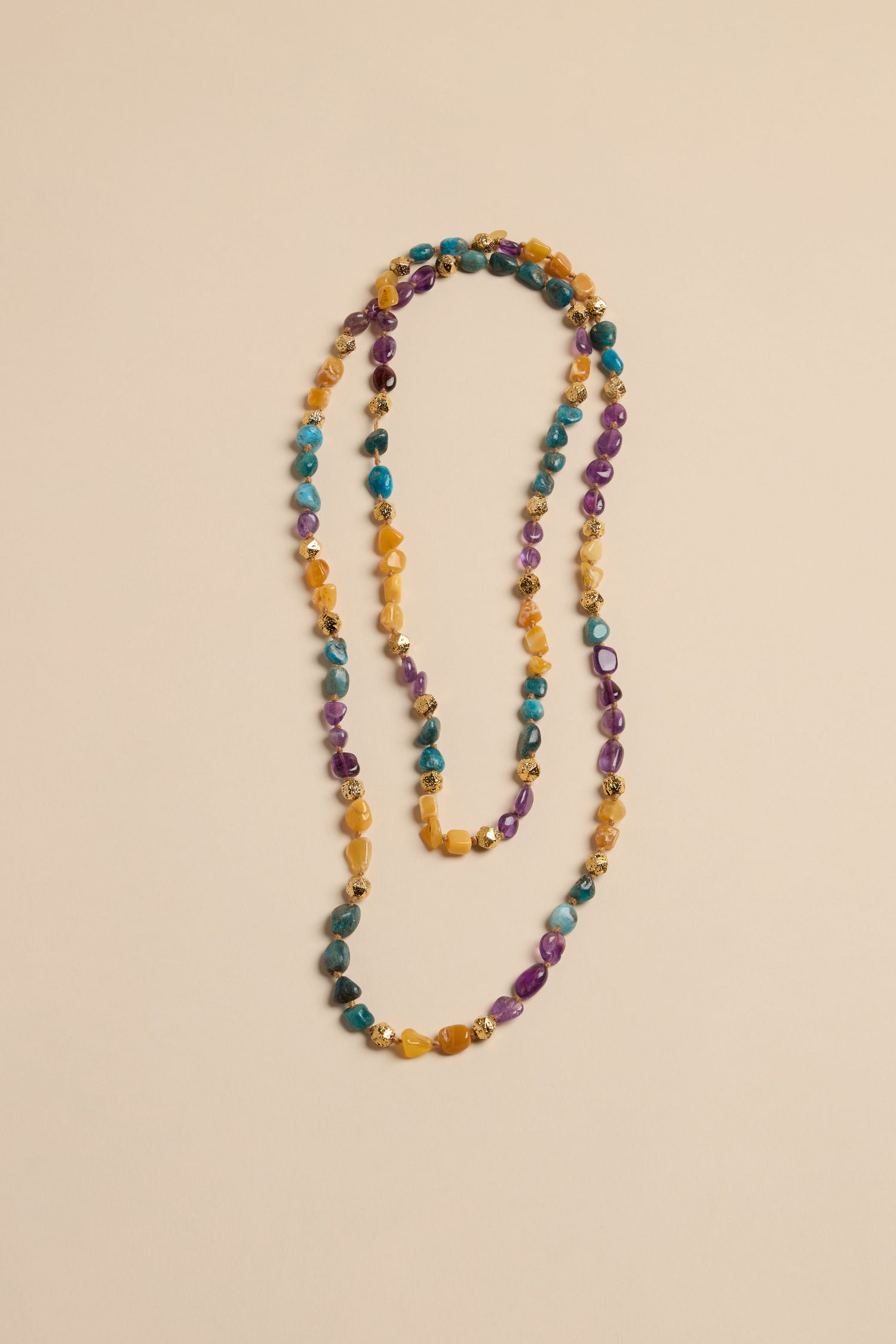Long Rainbow Bead Necklace made of multicolored stone beads accented with small gold-toned metal spacers.