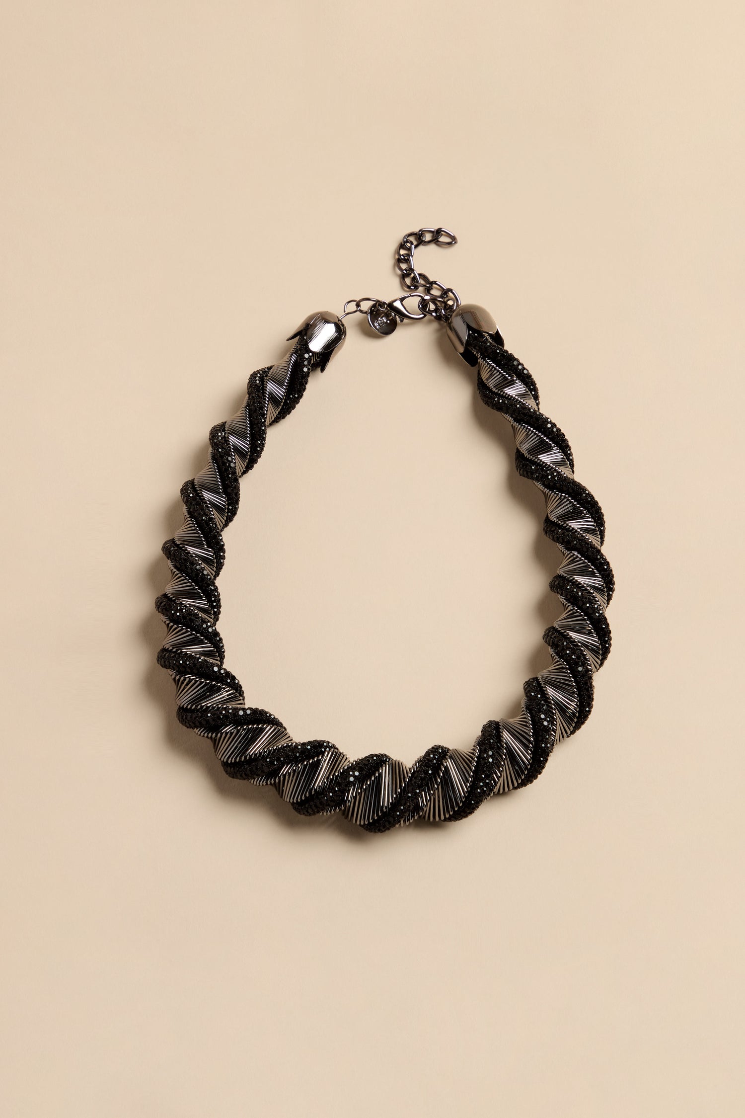 The Midnight Helix necklace features a twisted statement design with alternating bands of black crystal beads and metallic silver ribbing.