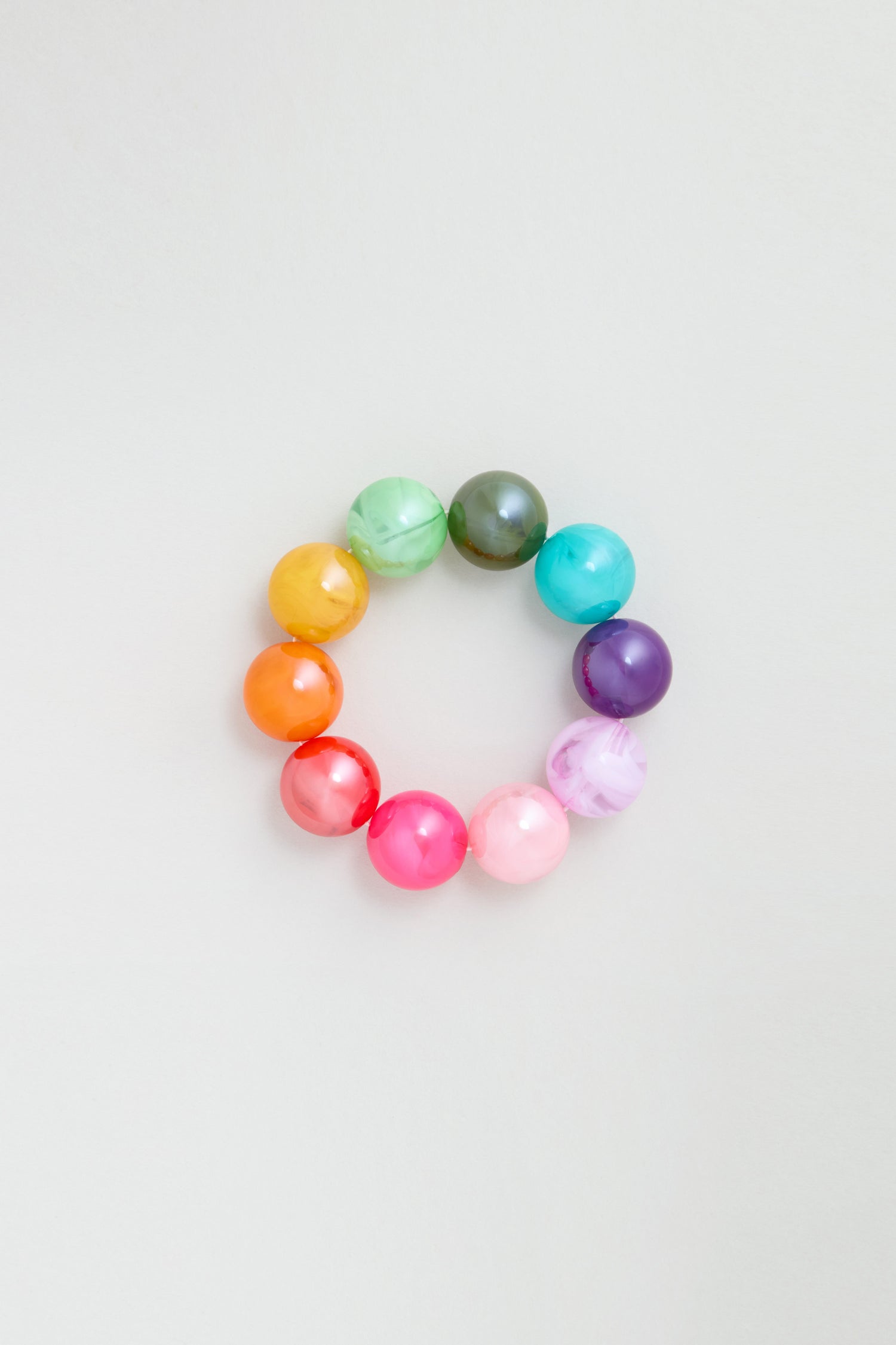 The Colour Pop Resin Spheres Bracelet features twelve large, glossy resin spheres in a circular rainbow arrangement, showcased against a plain light background.