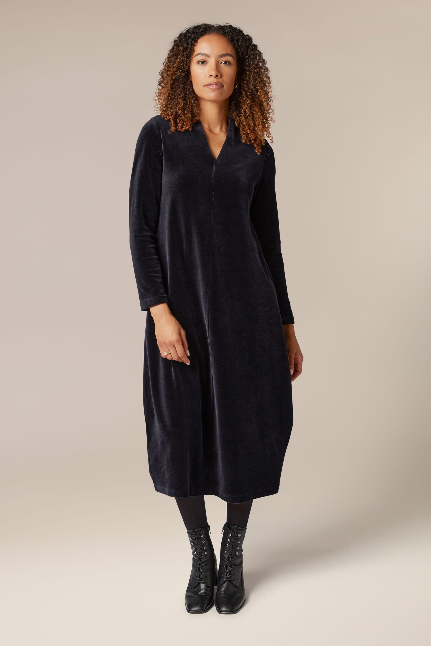 A woman wearing a luxurious Velvet Jersey V Neck Dress.