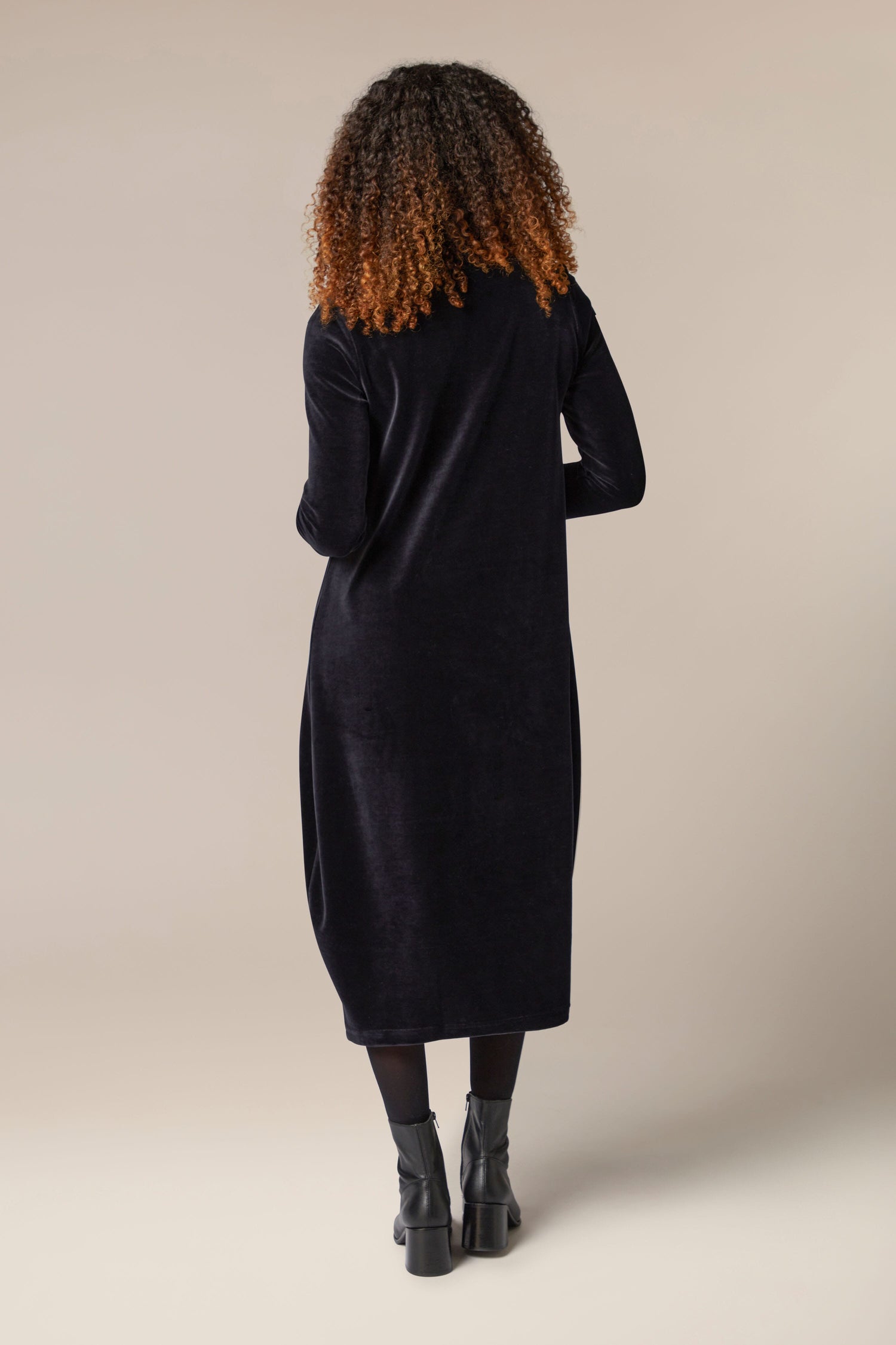 The back view of a woman wearing a luxurious Velvet Jersey V Neck dress.