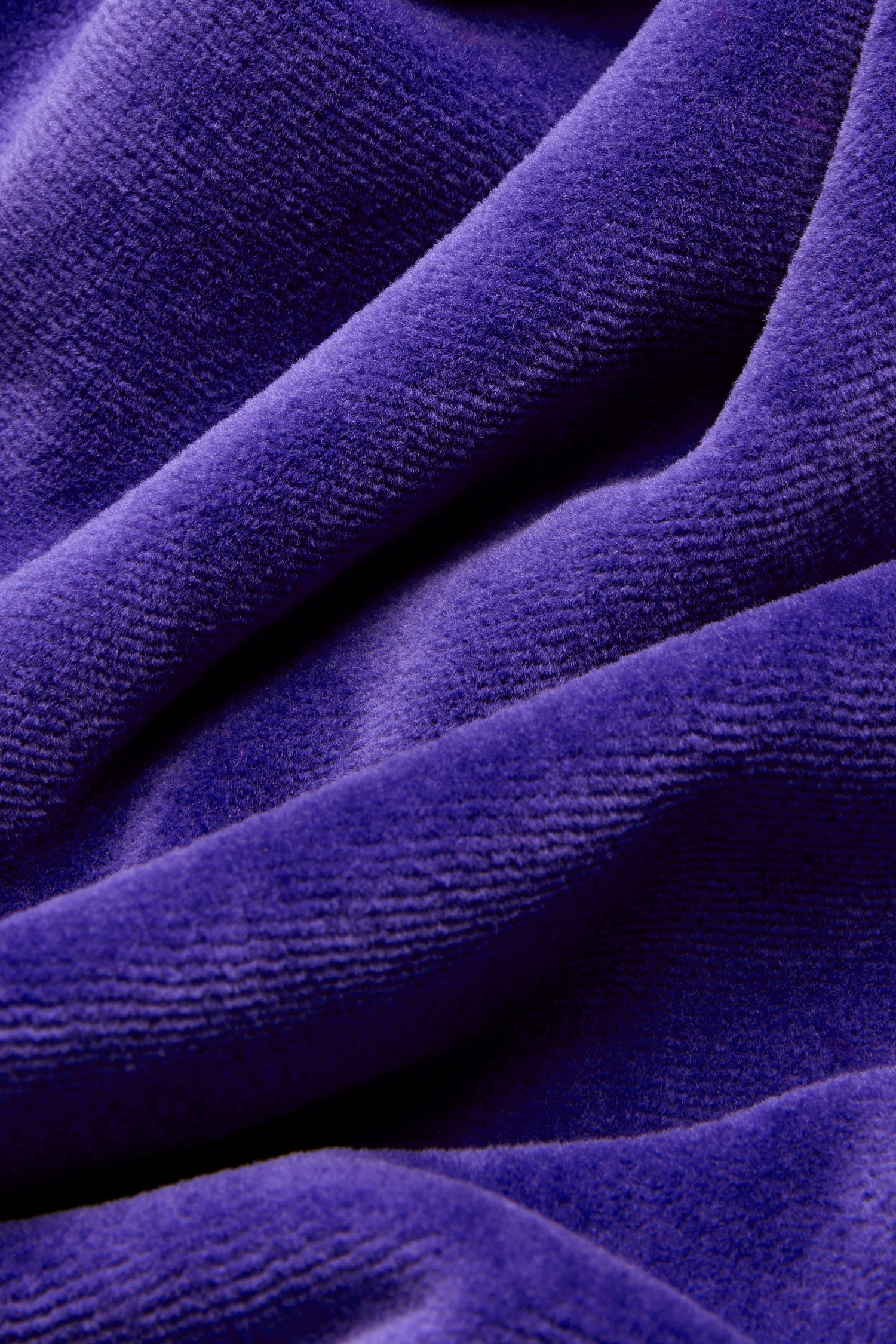 Close-up of deep purple cotton-rich velvet jersey fabric with a visibly soft texture and gentle folds, evoking the luxurious look and feel of the Velvet Jersey Bubble Dress.