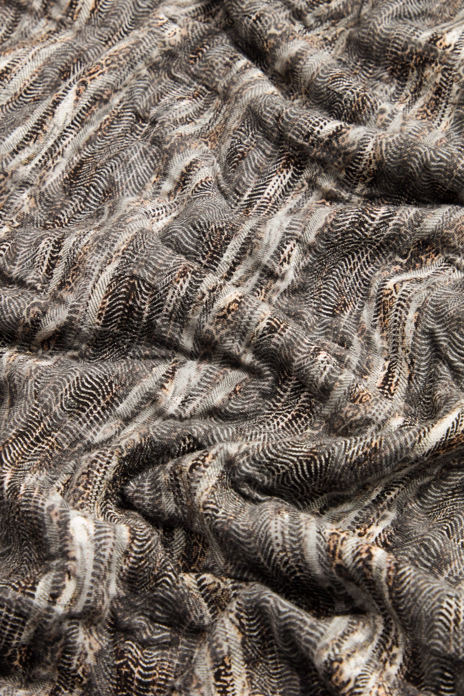 Close-up of the Abstract Ripple Jersey Bubble Dress, showcasing wavy, textured jersey fabric in black, white, and brown with small dotted and striped patterns.