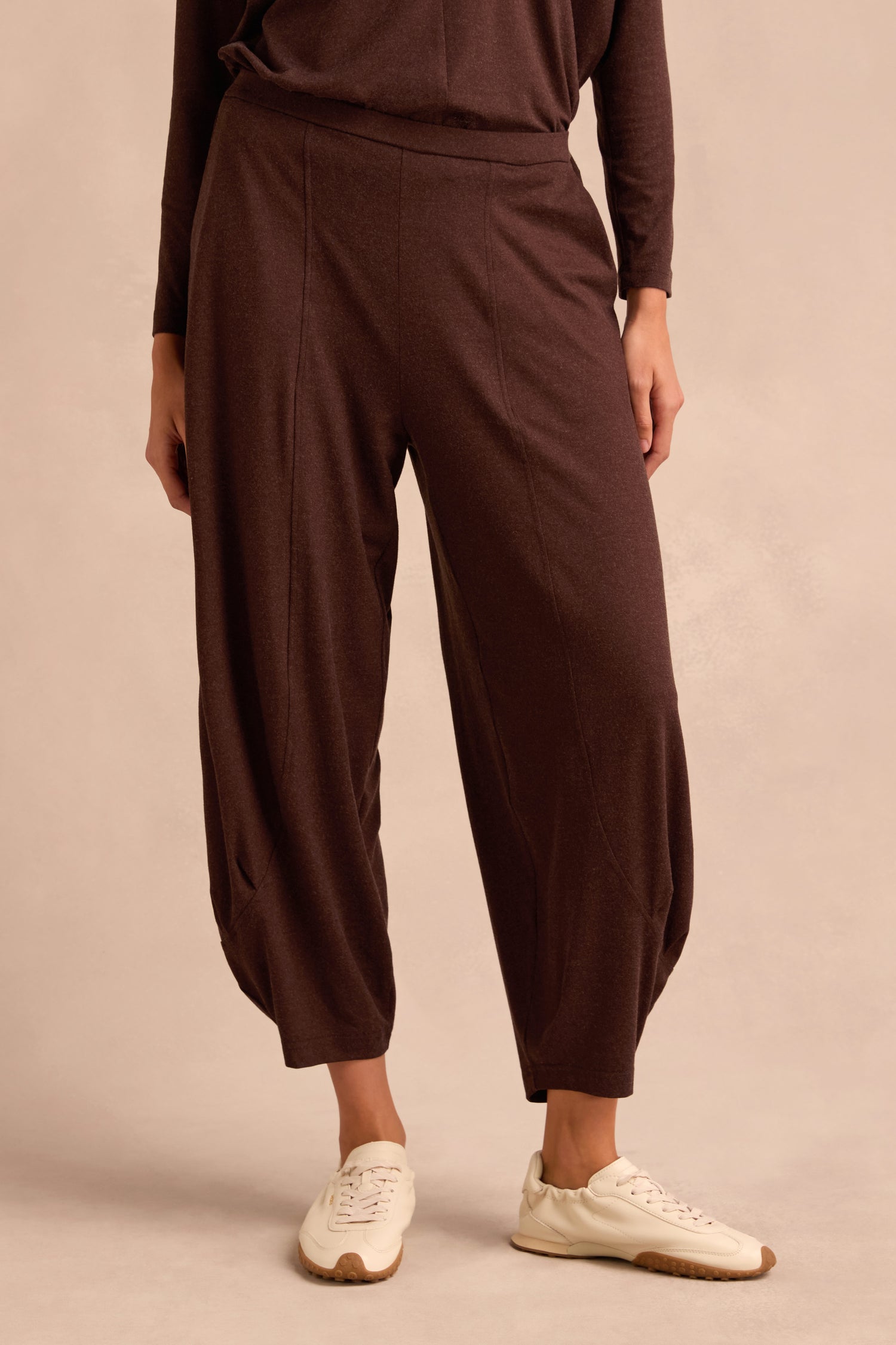 Wearing the Soft Viscose Jersey Bubble Trouser in a relaxed fit, paired with cream sneakers, the model stands against a neutral background, with only the lower half of the body visible.