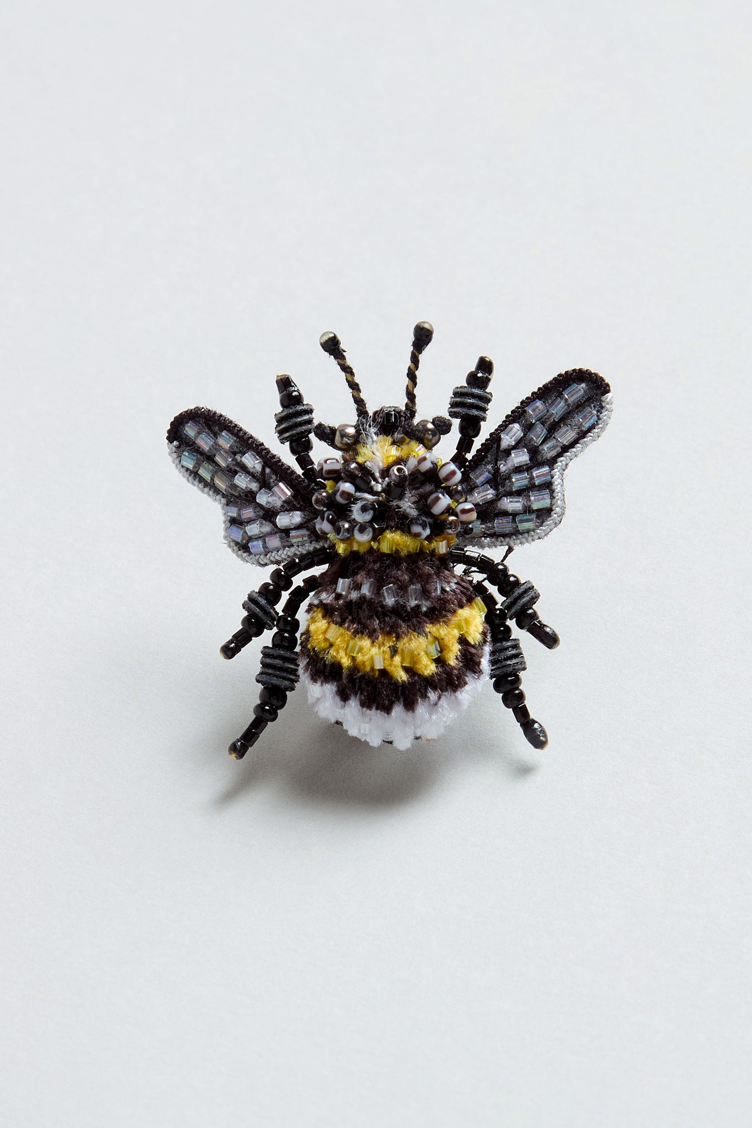 A Hand Beaded Yellow-Banded Bee Brooch, crafted from beads and fabric, is displayed on a plain light background.