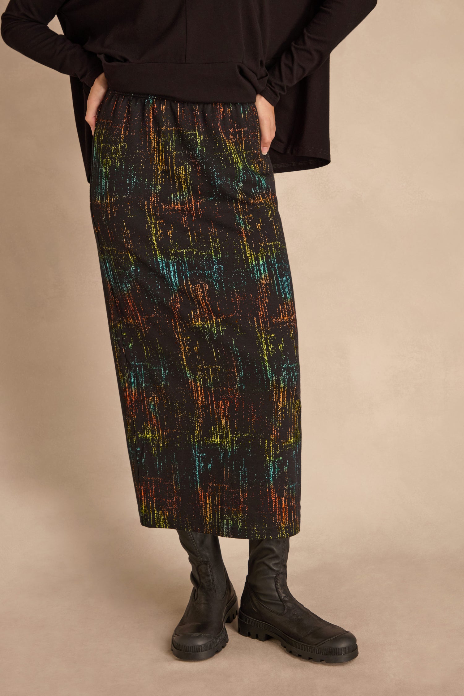 Person wears the Space Dye Jacquard Tube Skirt with a black top and boots, standing against a neutral background.