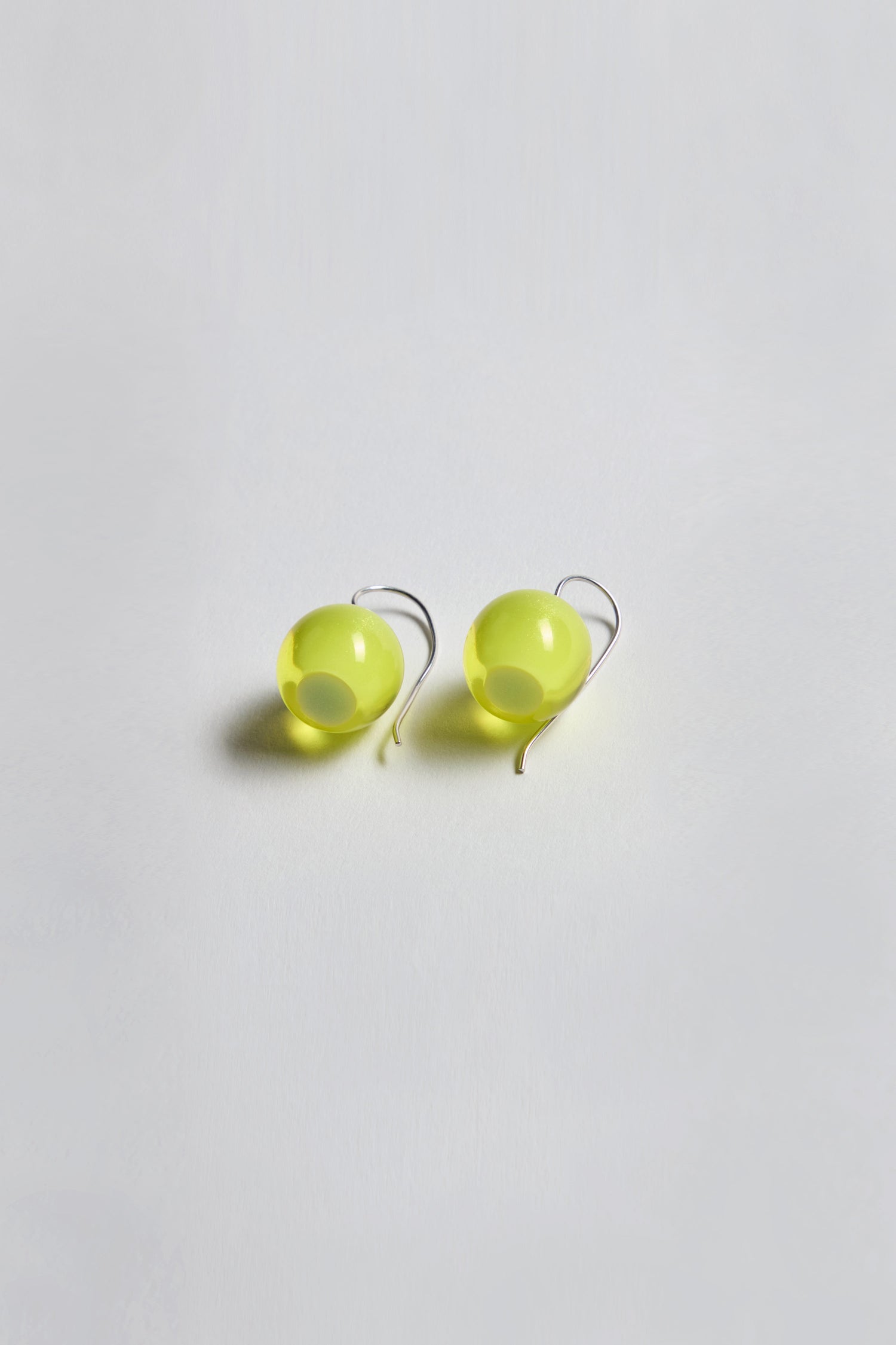 Exquisitely crafted and part of the Bellisima Collection, the Colourful Bead Earrings feature bright yellow resin beads with silver hooks, elegantly showcased on a white background.