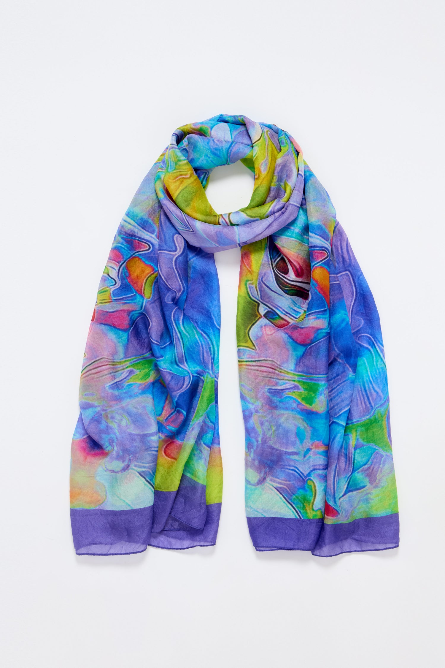 The Tiffany Lamp Silk Scarf showcases abstract stained glass-inspired patterns in blue, green, purple, red, and yellow on silk, set against a white background.