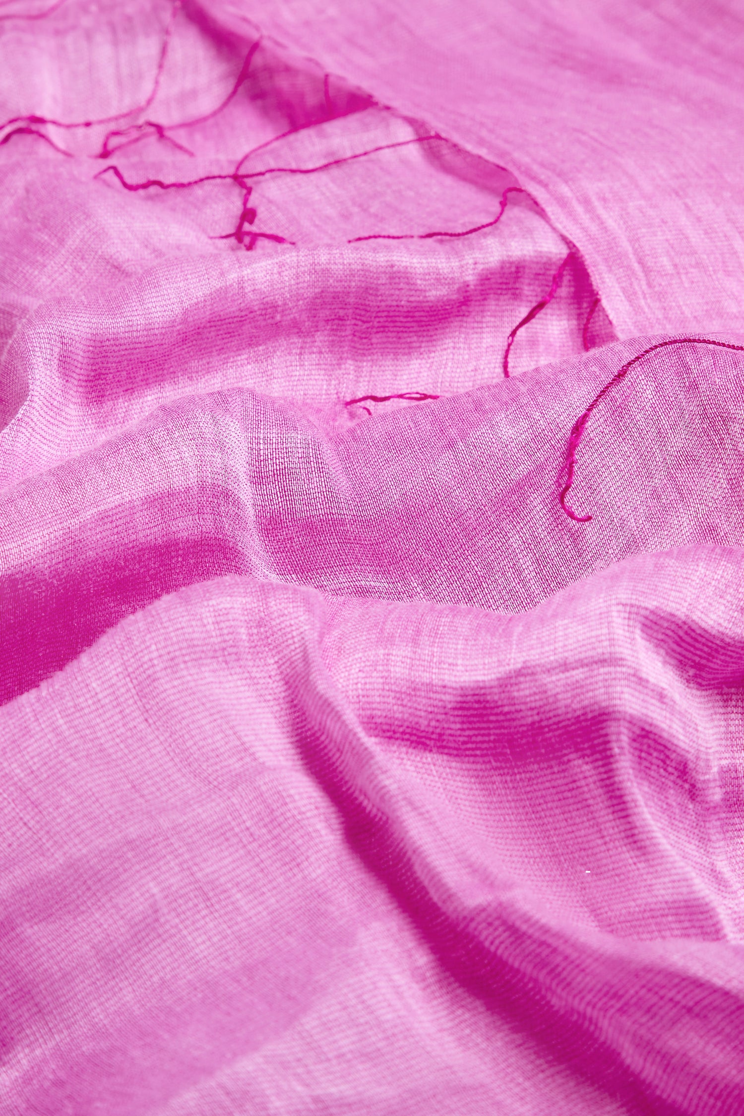 Close-up of the Soft Linen Fringe Scarf in pink, showing its crumpled sheer fabric and loose threads, perfect for lightweight layering or wearing as a fair trade accessory.