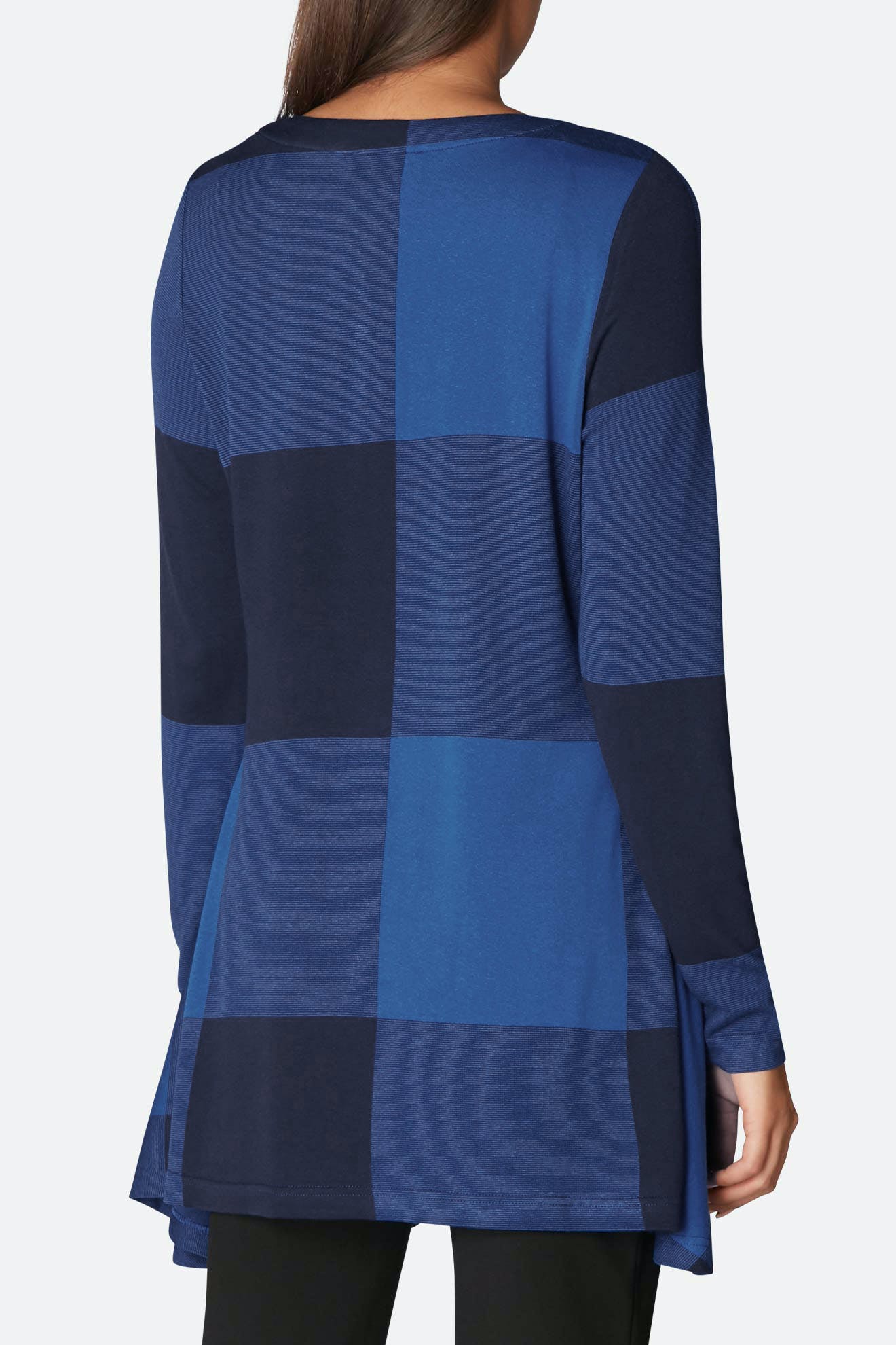 A person wearing a Large Check Jersey Flared Top, featuring long sleeves and an oversized check jacquard pattern in blue and dark blue, is shown from the back.
