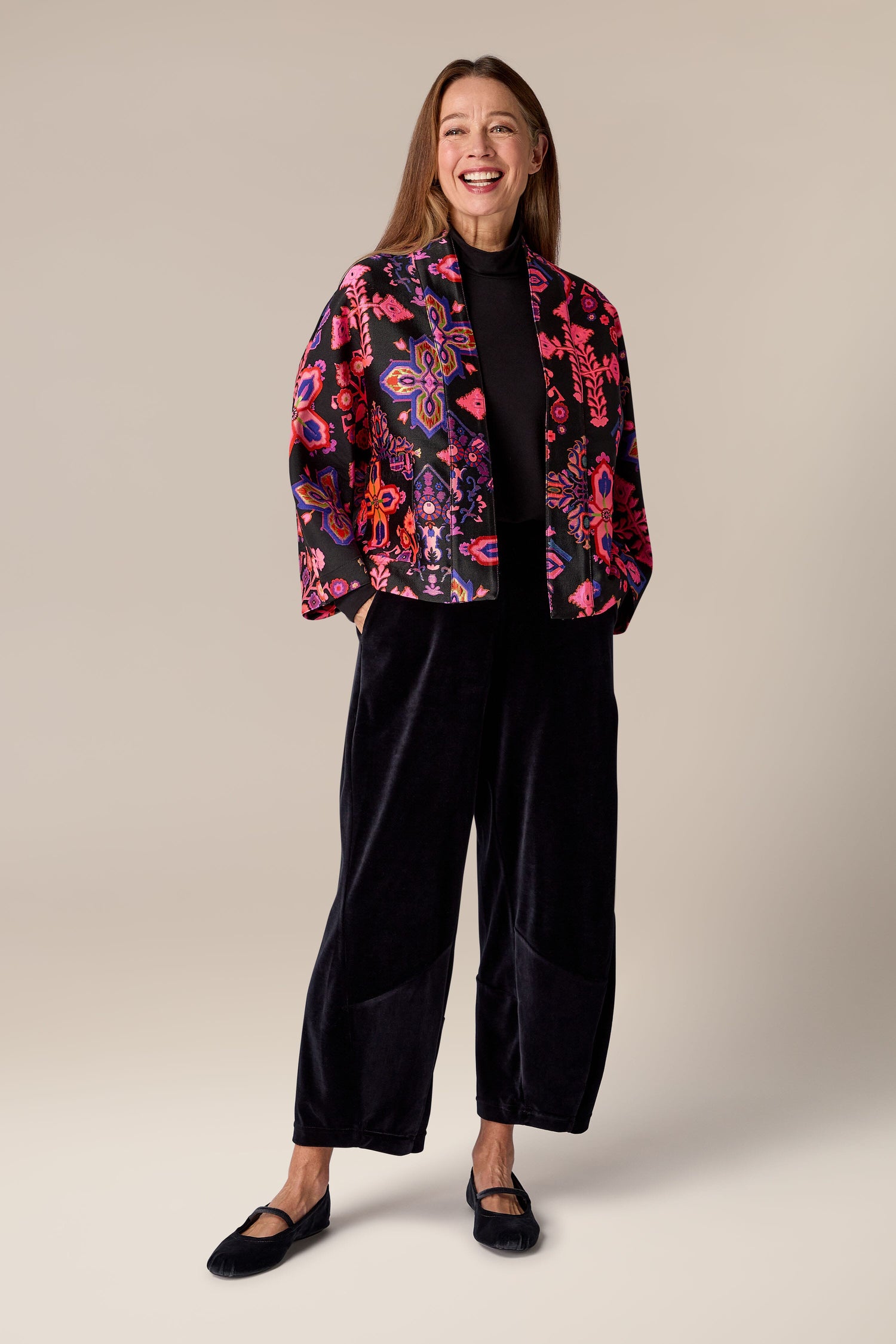 A woman wearing Jacquard Aztec Floral Jacket and black pants with a floral jacquard Aztec Floral Jacket.