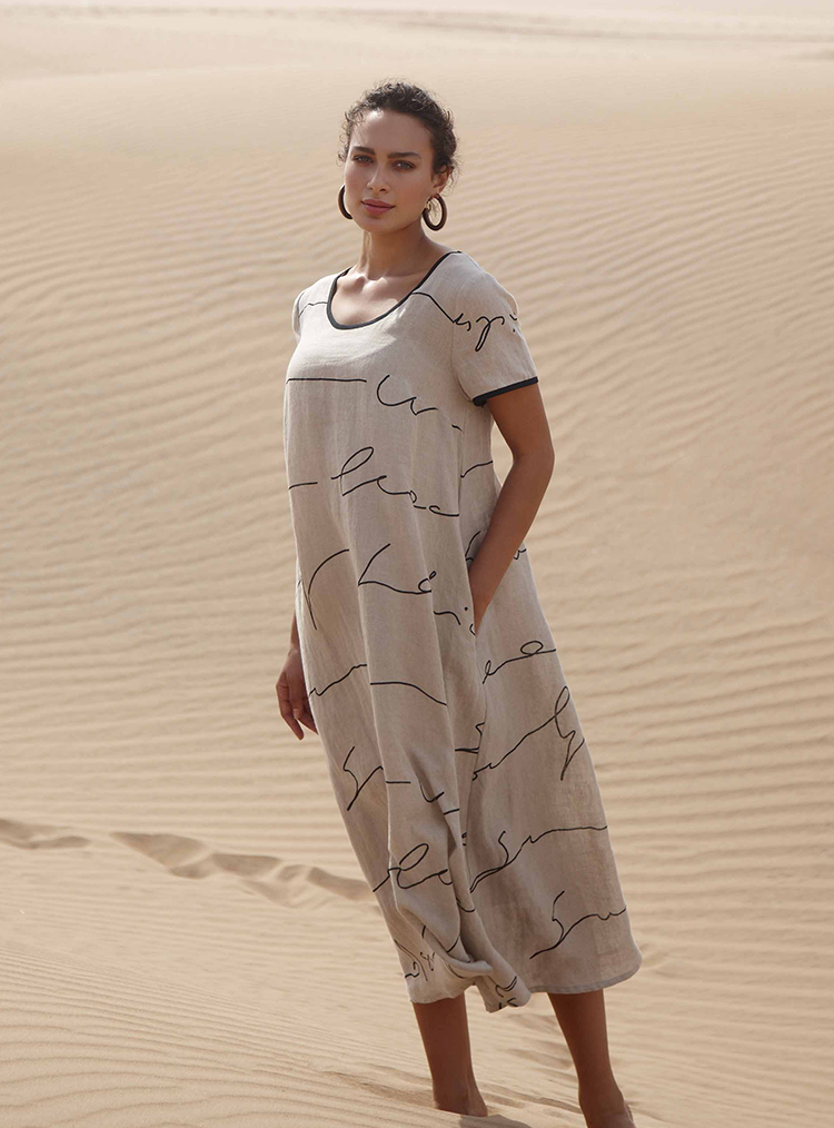 woman in white long dress stood in a desert