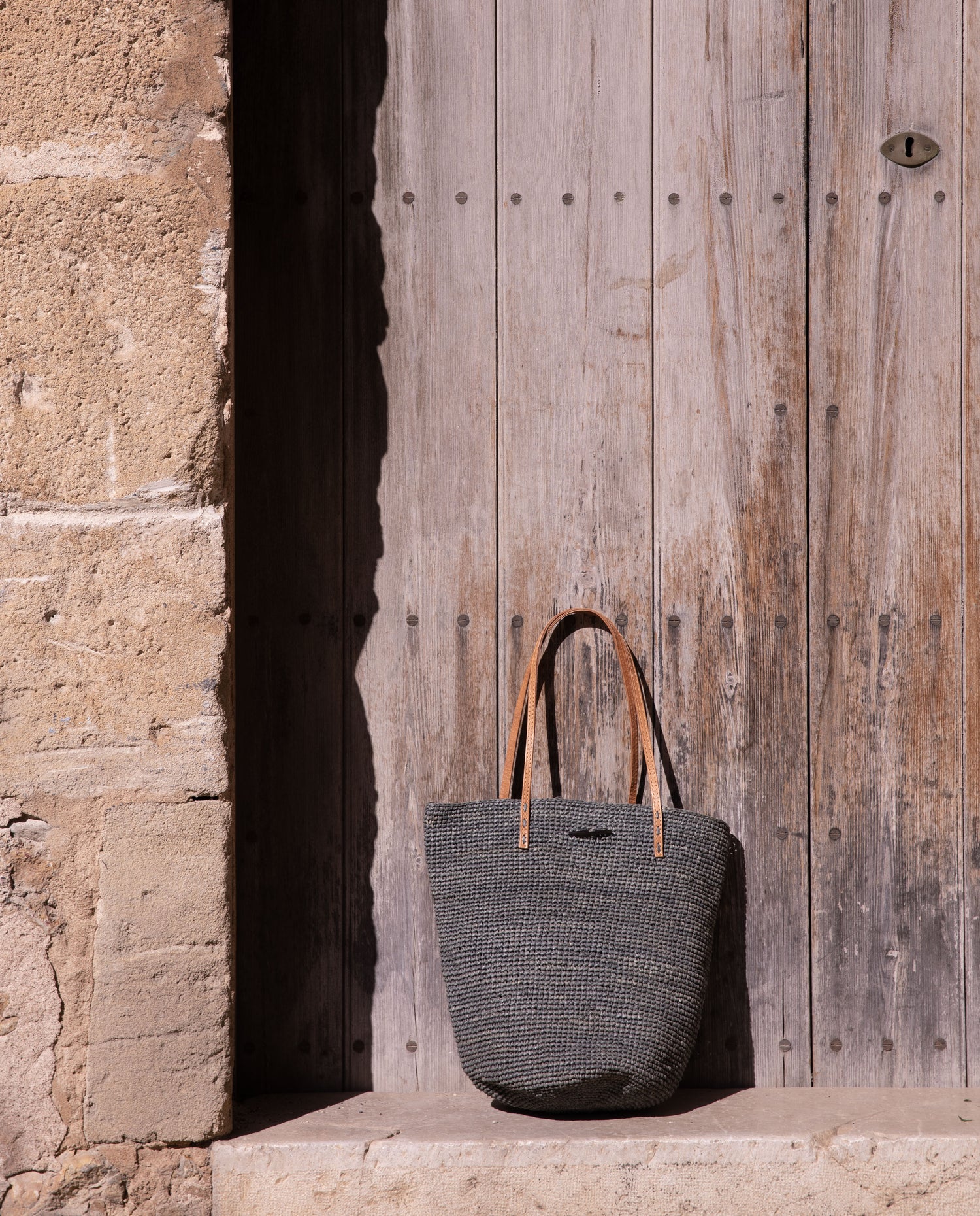 woven bag resting against a wooden door