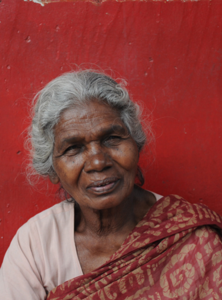 indian woman sat in front of a red wall