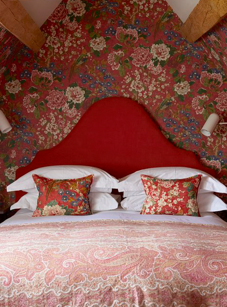 red headboard against floral red wallpaper