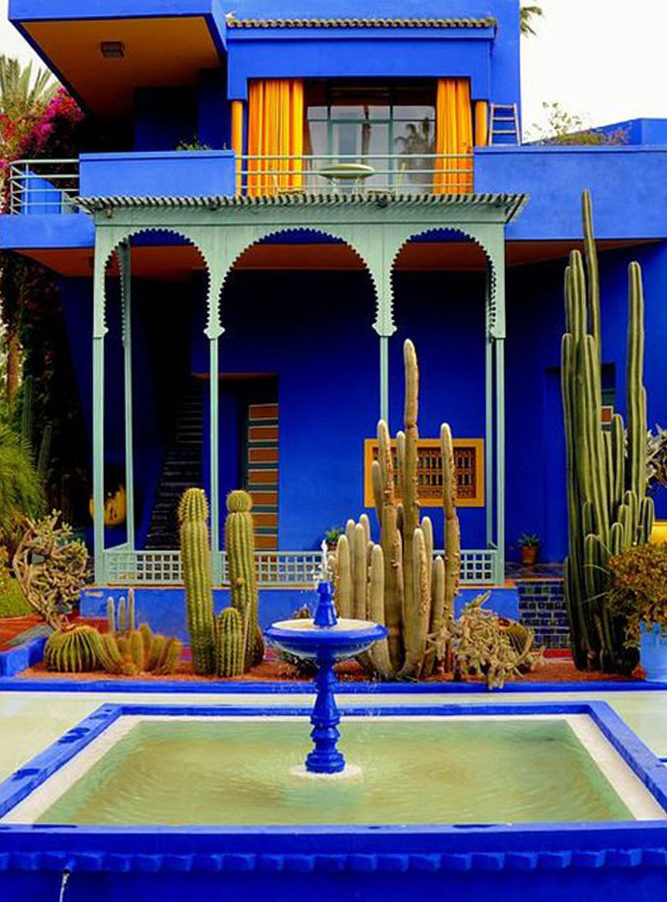 blue house and water feature with cacti