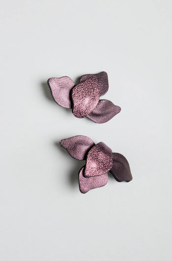 A pair of Metallic Burgundy Leather Petal Earrings are displayed on a plain light gray background.