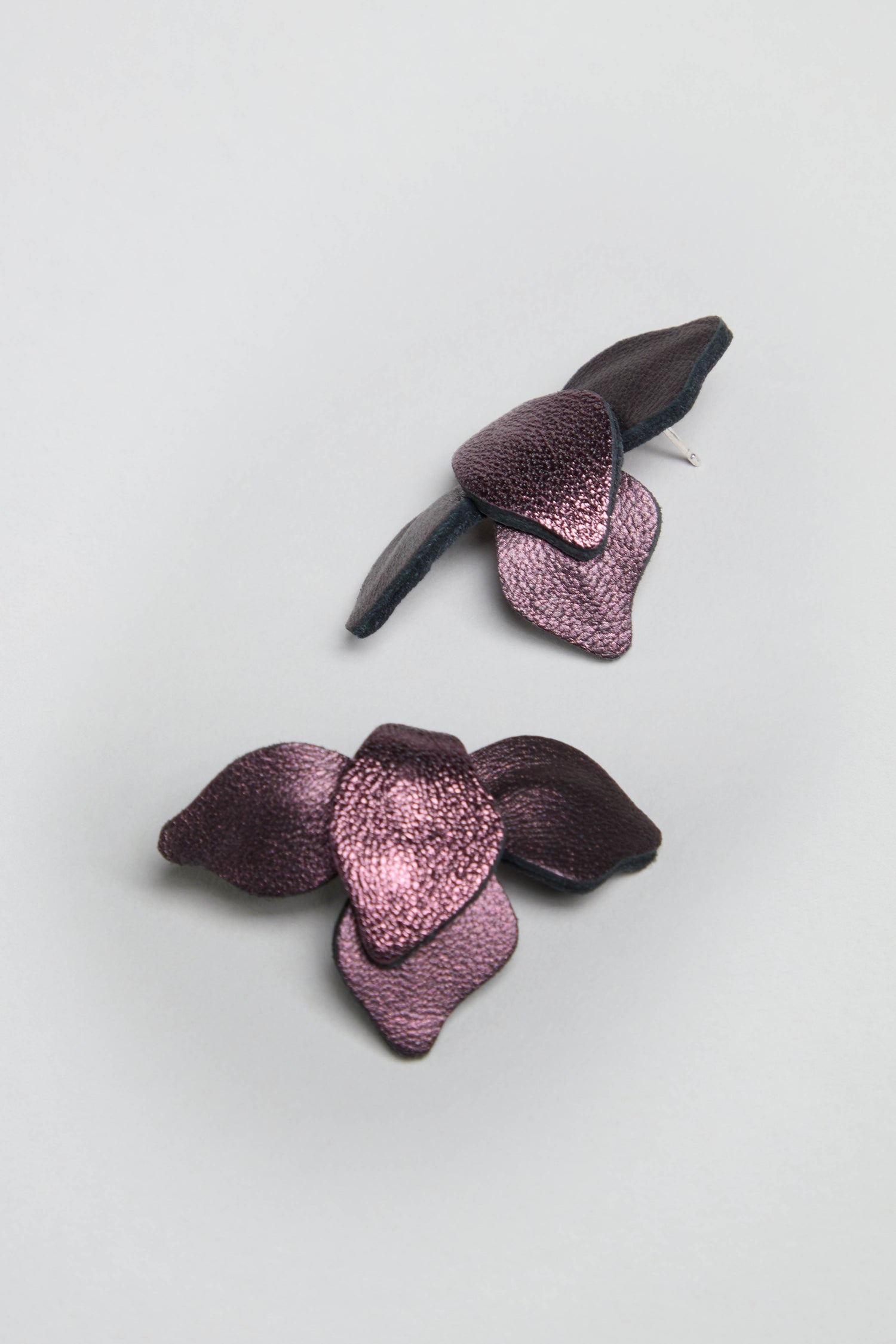Metallic Burgundy Leather Petal Earrings are displayed on a light grey background.