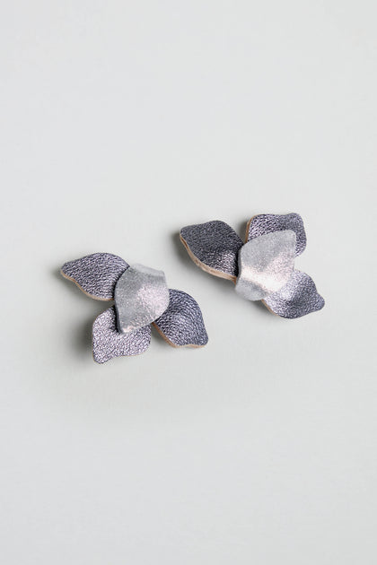Metallic Grey Leather Petal Earrings in silver and lavender leather, shaped as abstract flowers, shown on a light grey background.