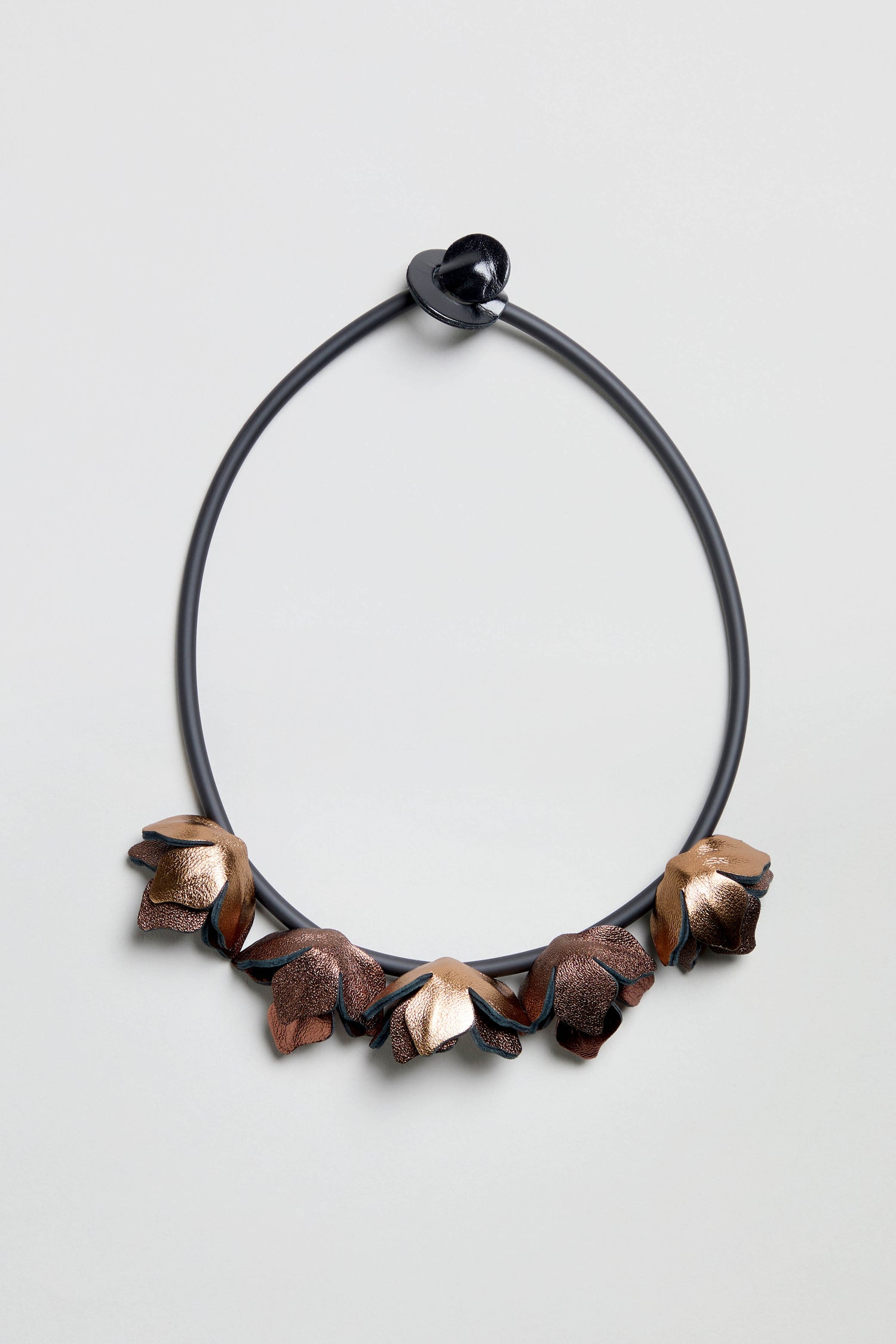 Short Metallic Leather Petals Necklace featuring metallic flower-shaped petals and a heart-shaped clasp, displayed against a plain light background.