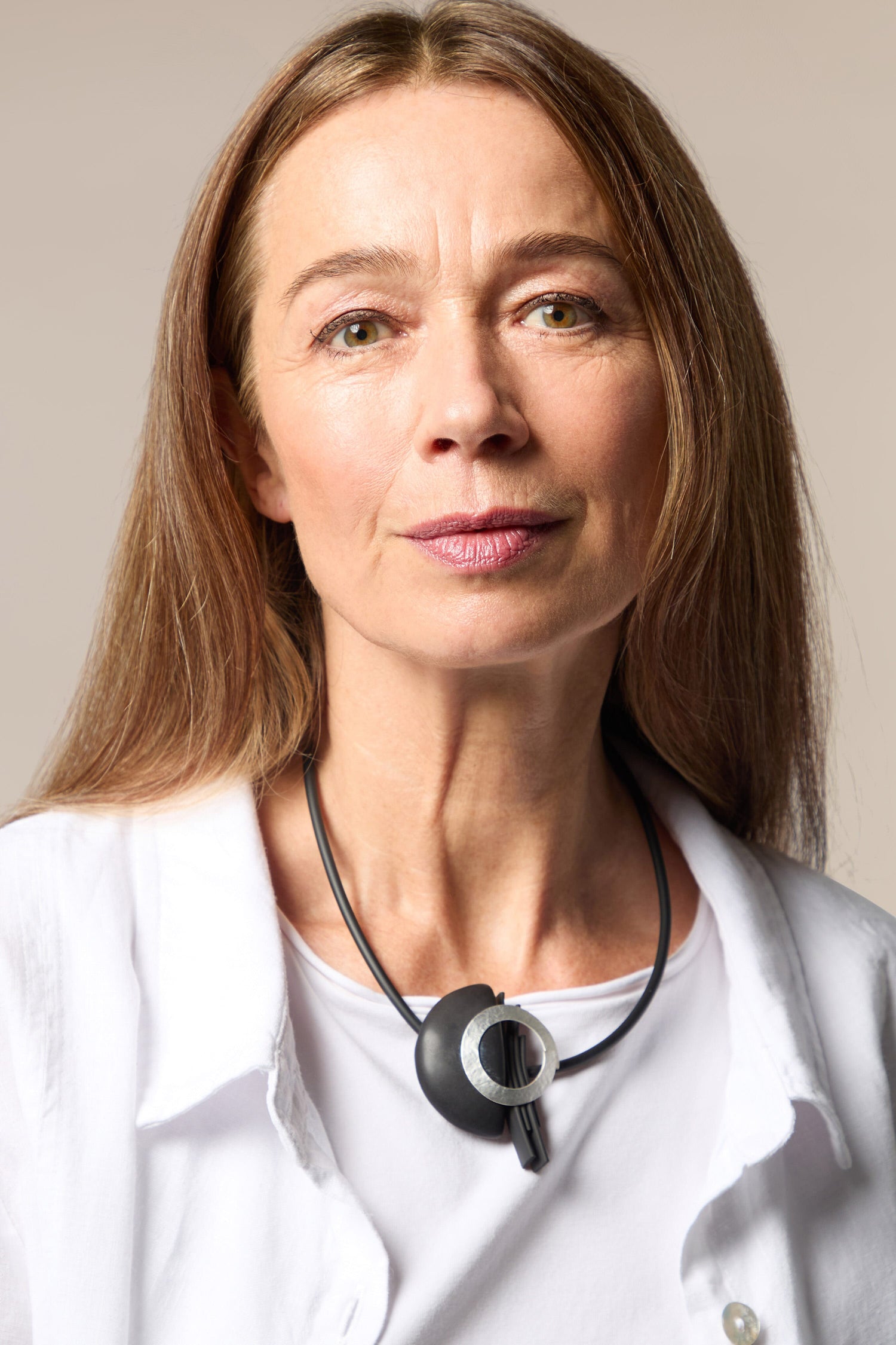 A woman in a white shirt with a stethoscope and Saturn Necklace.