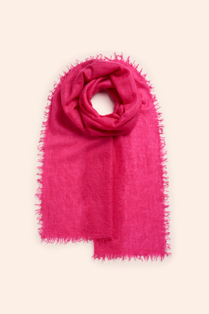 The Soft Weave Cashmere Scarf in bright pink is made from 100% cashmere and features a raw-edge tassel finish.