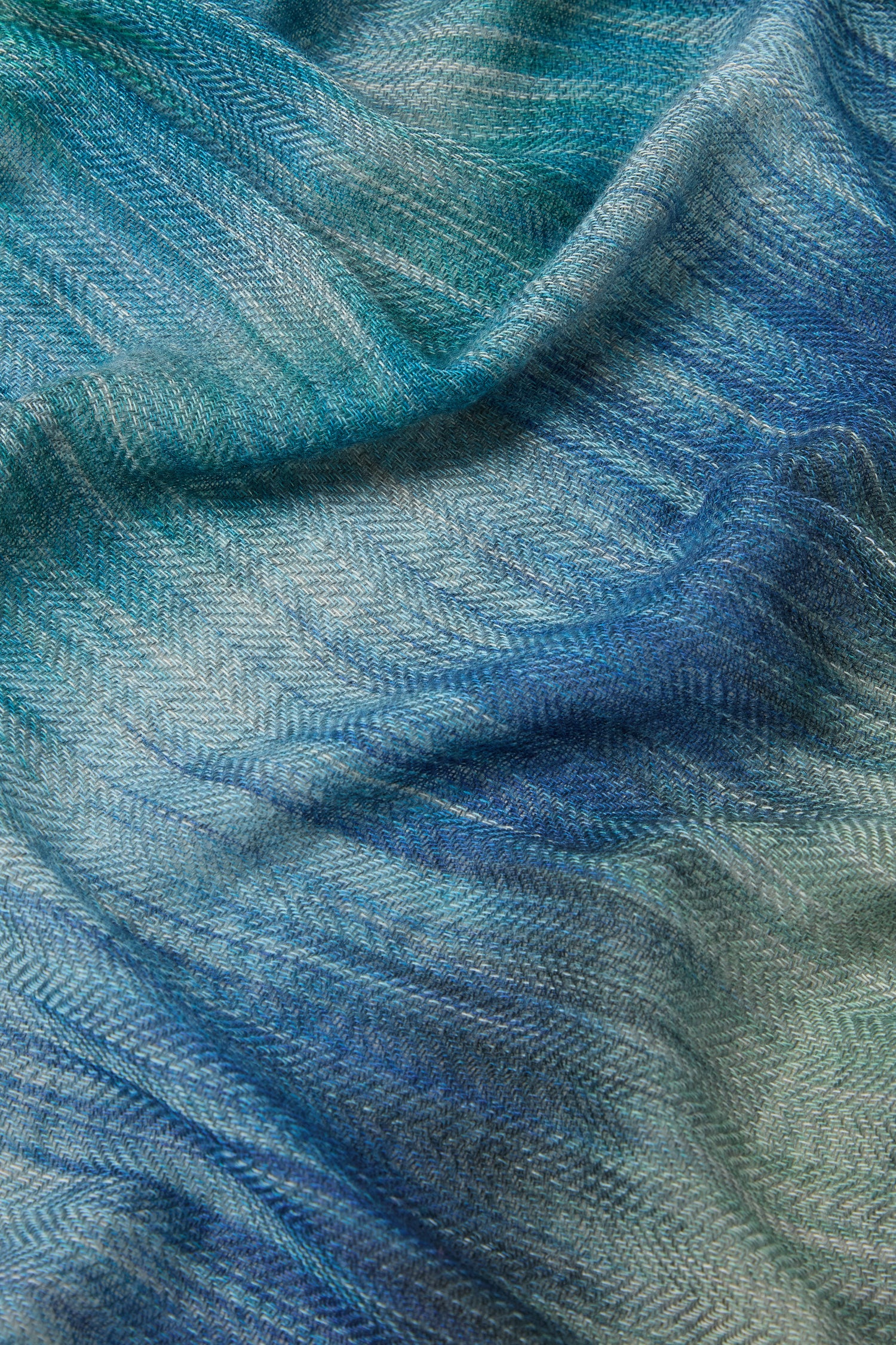 Close-up of an ultra-soft Sky Wool Cashmere Blend Scarf in blue and green, featuring a precise herringbone stitch pattern.