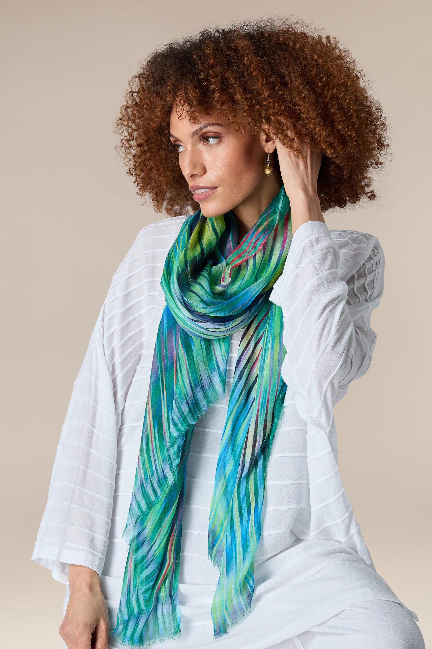 A woman wearing an Ikat Zig Zag Scarf with a pop of green and blue.