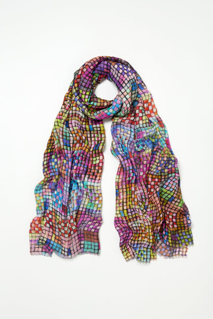 The Coloured Glass Tiles Scarf is a lightweight modal-silk blend featuring a colorful, mosaic-inspired checkered print in purple, blue, red, green, and yellow, shown laid flat on a white background.