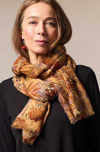 A woman wearing a Paradise Sequin Detail Wool Scarf with an intricate floral pattern.