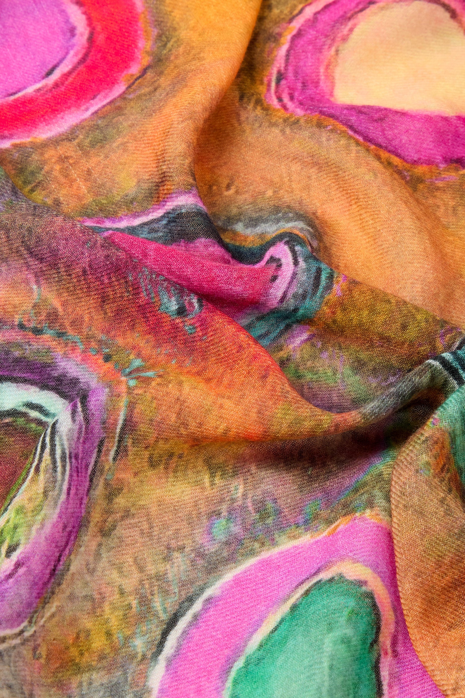 Close-up of a colorful fabric with abstract patterns in shades of pink, green, orange, and yellow, showcasing a vibrant and textured design reminiscent of the Watercolour Circles Wool Mix Scarf.