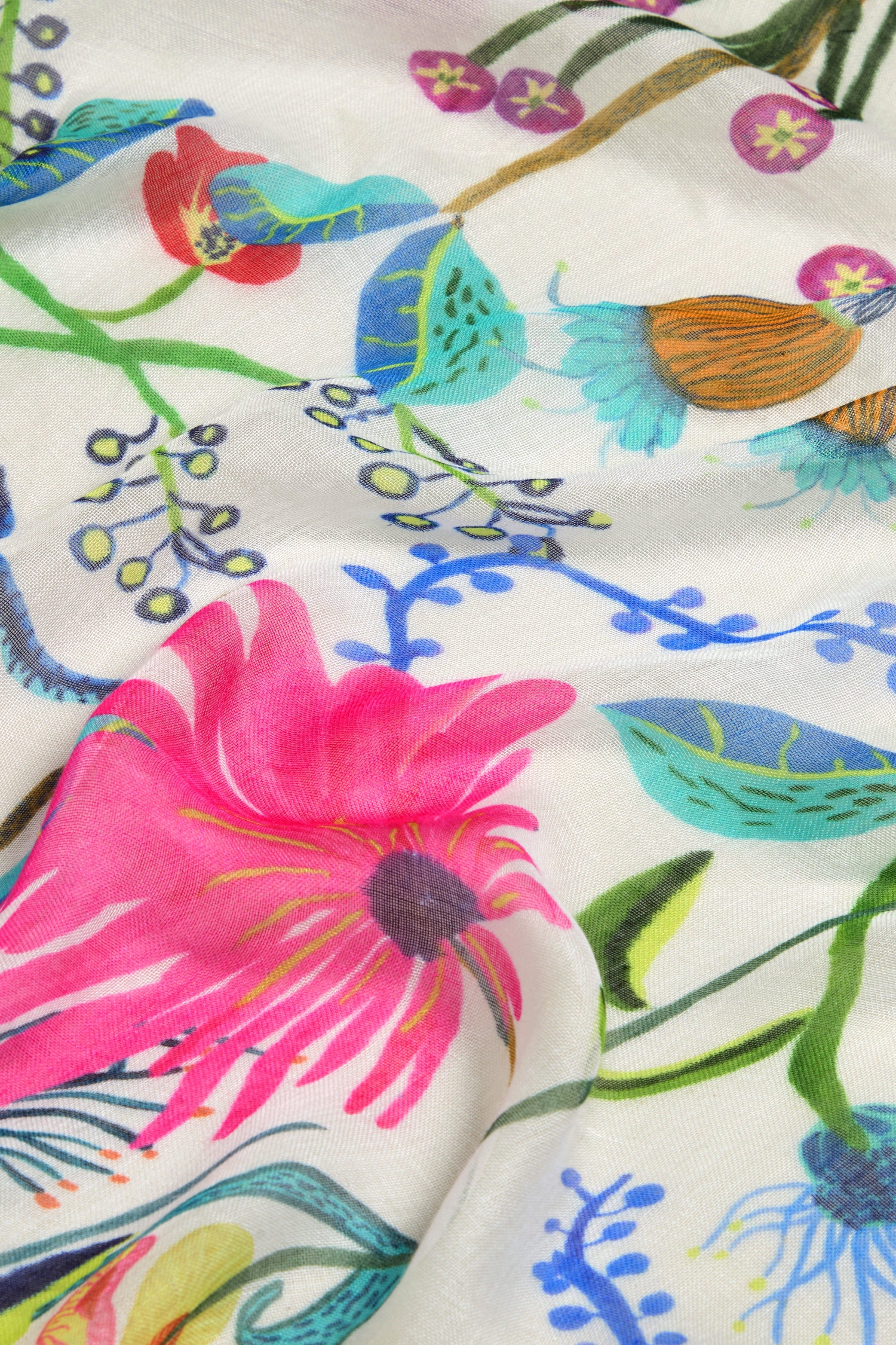 Close-up of the Wild Garden Scarf's vibrant floral pattern, showcasing pink, blue, and green flowers with stems and leaves against a light backdrop.