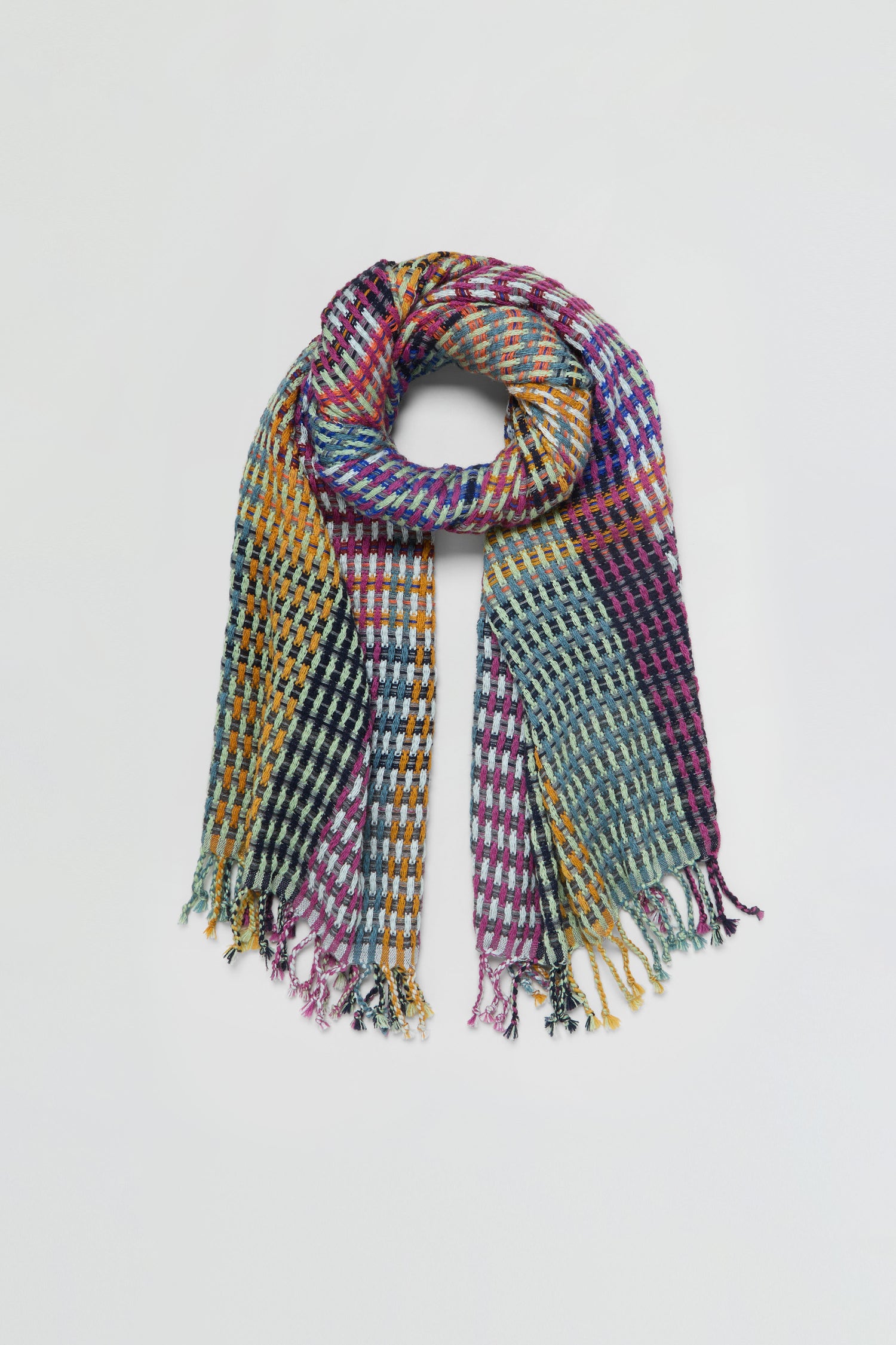 The Checkerboard Scarf features a colorful checkered pattern and fringed ends, crafted from a lightweight wool-blend for timeless style and warmth, displayed flat on a light background.