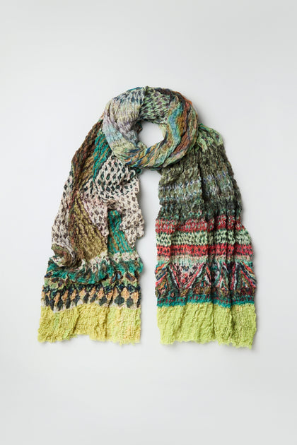 The Crushed Digital Print Wool Scarf, oversized and multicolored with textured patterns in green, yellow, red, blue, and beige, is displayed flat on a plain background.