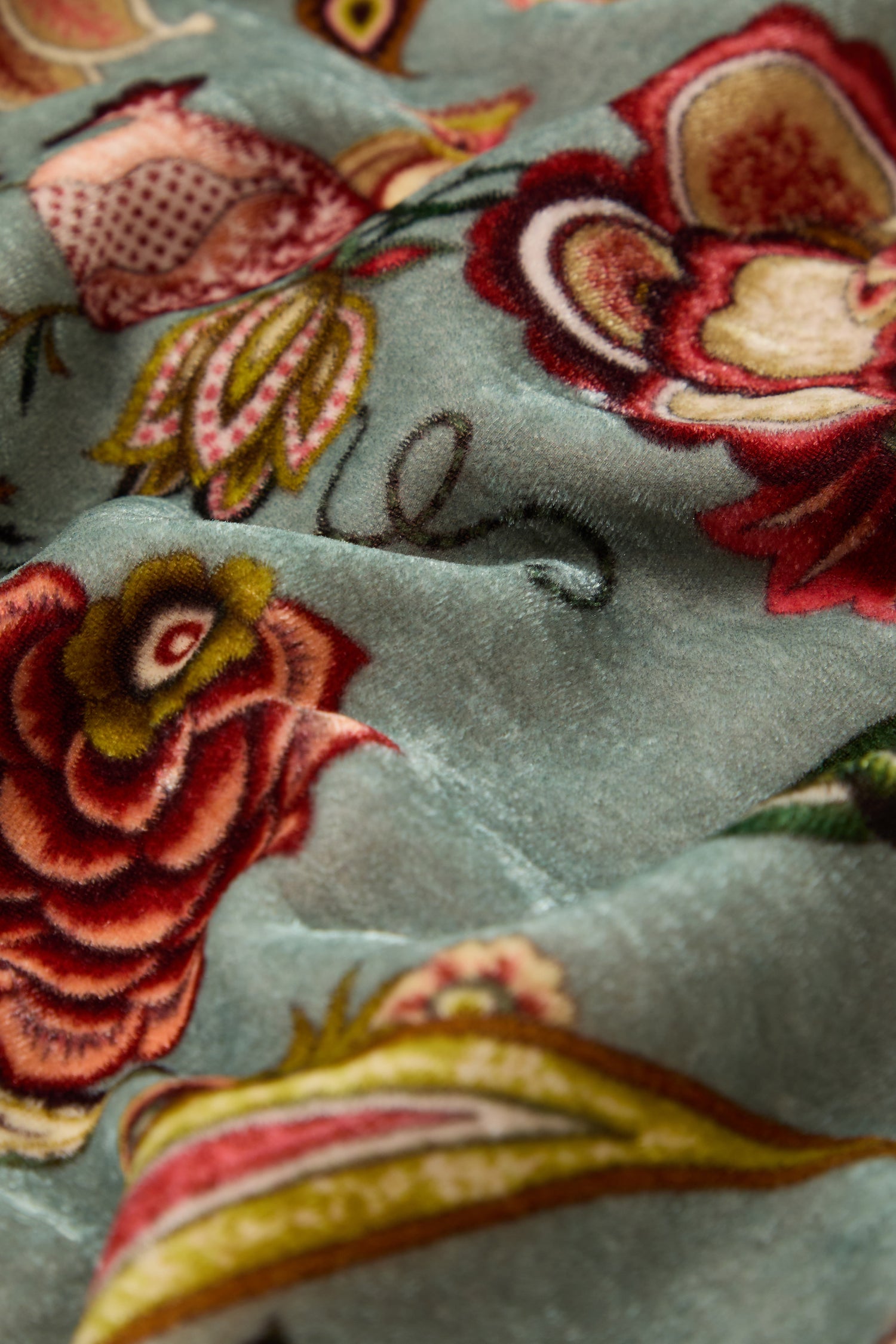 Close-up of the In Bloom Velvet Scarf in light blue, featuring a raised, colorful floral pattern—ideal for making a statement or adding vibrant style to any outfit.