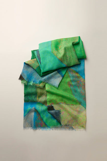 The Tide Sparkle Scarf showcases graceful elegance with its folded, multicolored design featuring green, blue, and earth tones on a neutral backdrop. Crafted from lightweight fabric, it seamlessly blends style and comfort.